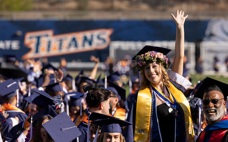 Student waves at commencement