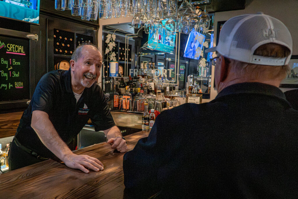 Bartender talking to customer.