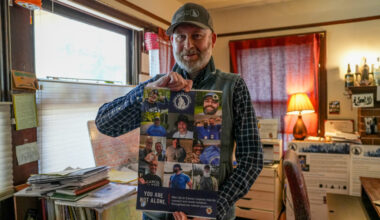 Brad Buchanan, NorCal chapter leader of Man Up to Cancer, holds a sign from the organization in his home. Photo by Denis Akbari.
