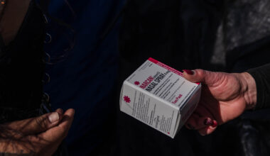 Tara Stamos-Buesig from the Harm Reduction Coalition hands out Narcan Nasal Spray to people living in a homeless encampment in downtown on Nov. 11, 2022.