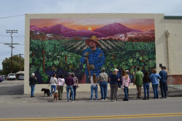 A crowd gathers in front of the Ramona mural, "Tending the Vineyard" at a previous H.E.A.R.T mural walking tour. (Michelle Sund)