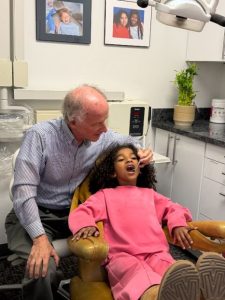 Dentist giving "exam" to child at new Boys & Girls Clubs of Oakland Free Dental Clinic