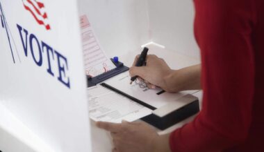 A voter pushes a pin to indicate a vote on a ballot in a voting center during an election.