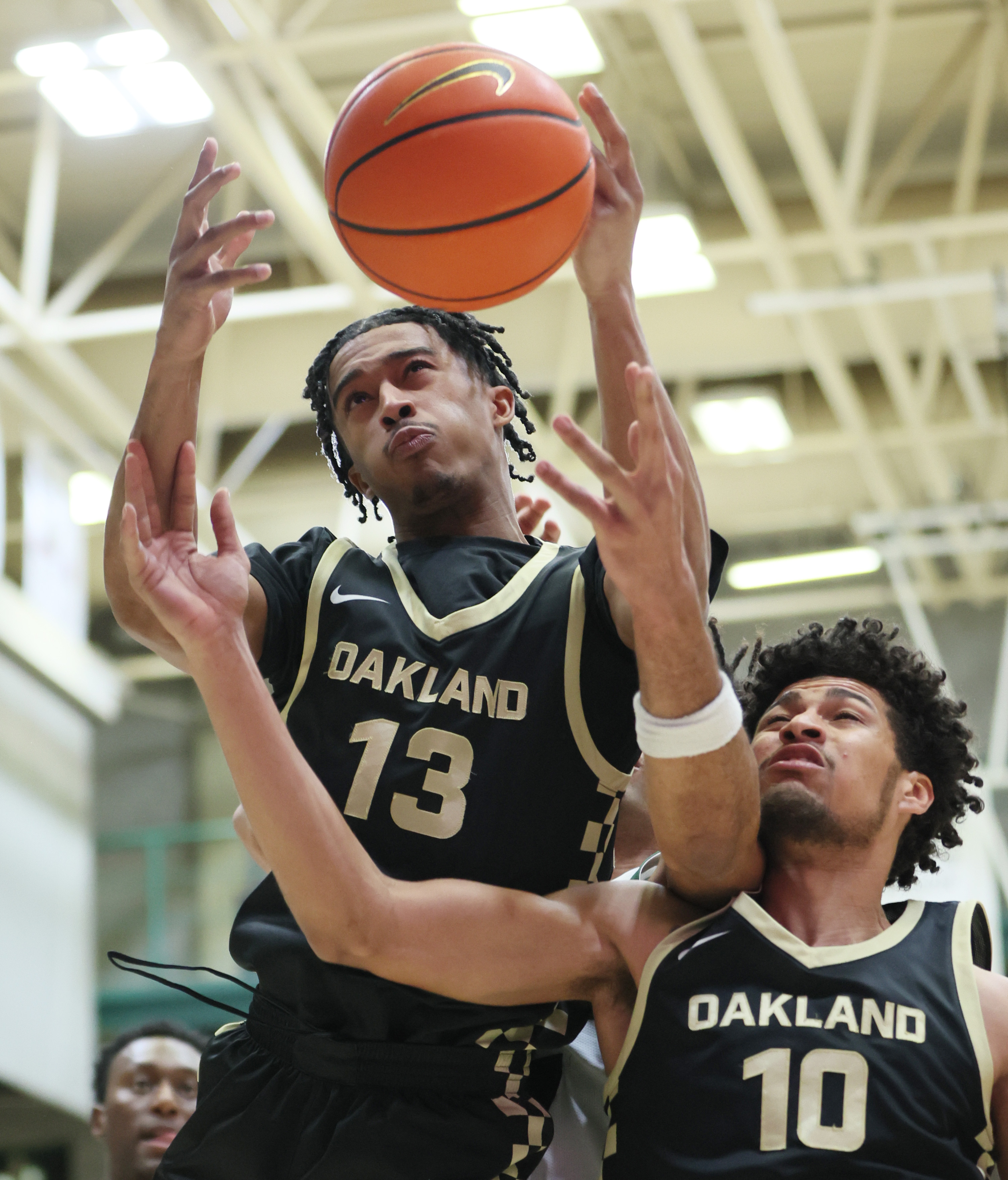 Oakland Golden Grizzlies guard Warren Marshall IV (13) and Oakland Golden Grizzlies guard Brett White reach for a rebound in the first half.