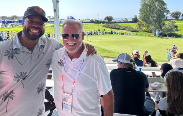 Service member Joseph Swann (left) enjoys the Patriots' Outpost alongside Joe Balla, president of the Harbaugh Foundation that sponsors the 13th hole venue. (Kirk Kenney / San Diego Union-Tribune)