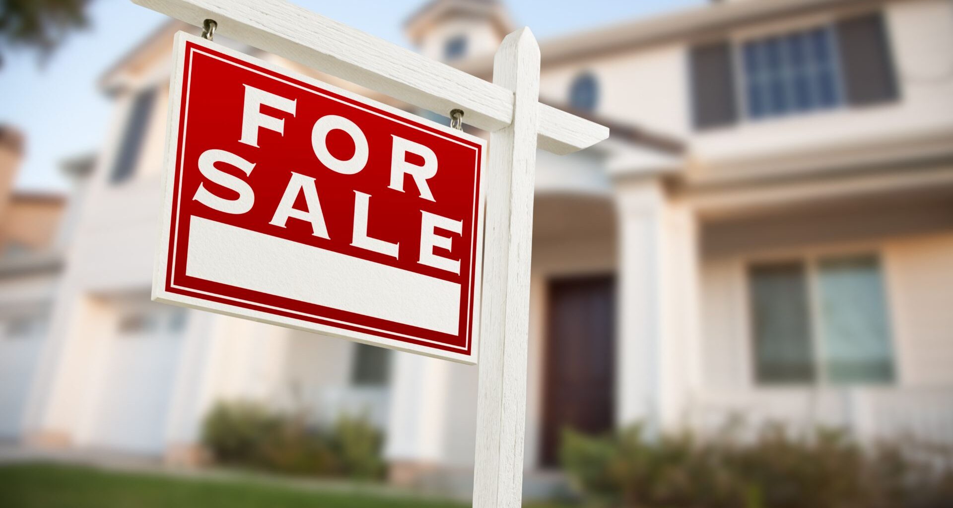 For sale home sign in front of a new construction home.