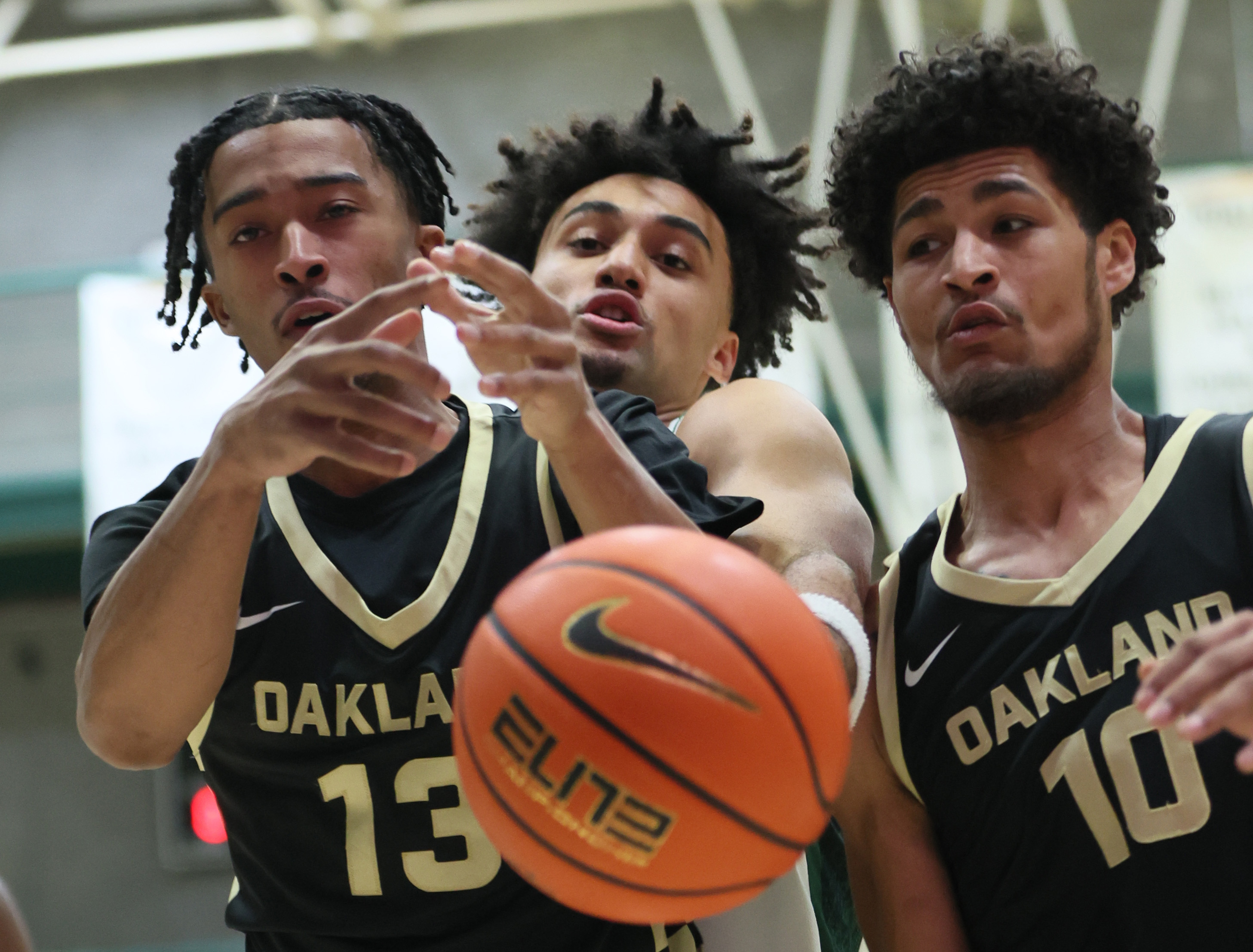 Oakland Golden Grizzlies guard Warren Marshall IV (13) and Oakland Golden Grizzlies guard Brett White (R) battle Cleveland State Vikings forward Dayan Nessah for possession of a rebound in the first half.