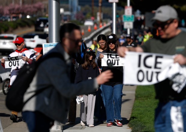 SANTA CLARA, CALIFORNIA - FEBRUARY 08: People pass out "ICE out" towels to football fans outside Levi's Stadium before the start of Super Bowl LX on February 08, 2026 in Santa Clara, California. The New England Patriots will take on the Seattle Seahawks in Super Bowl LX at Levi's Stadium. (Photo by Justin Sullivan/Getty Images)