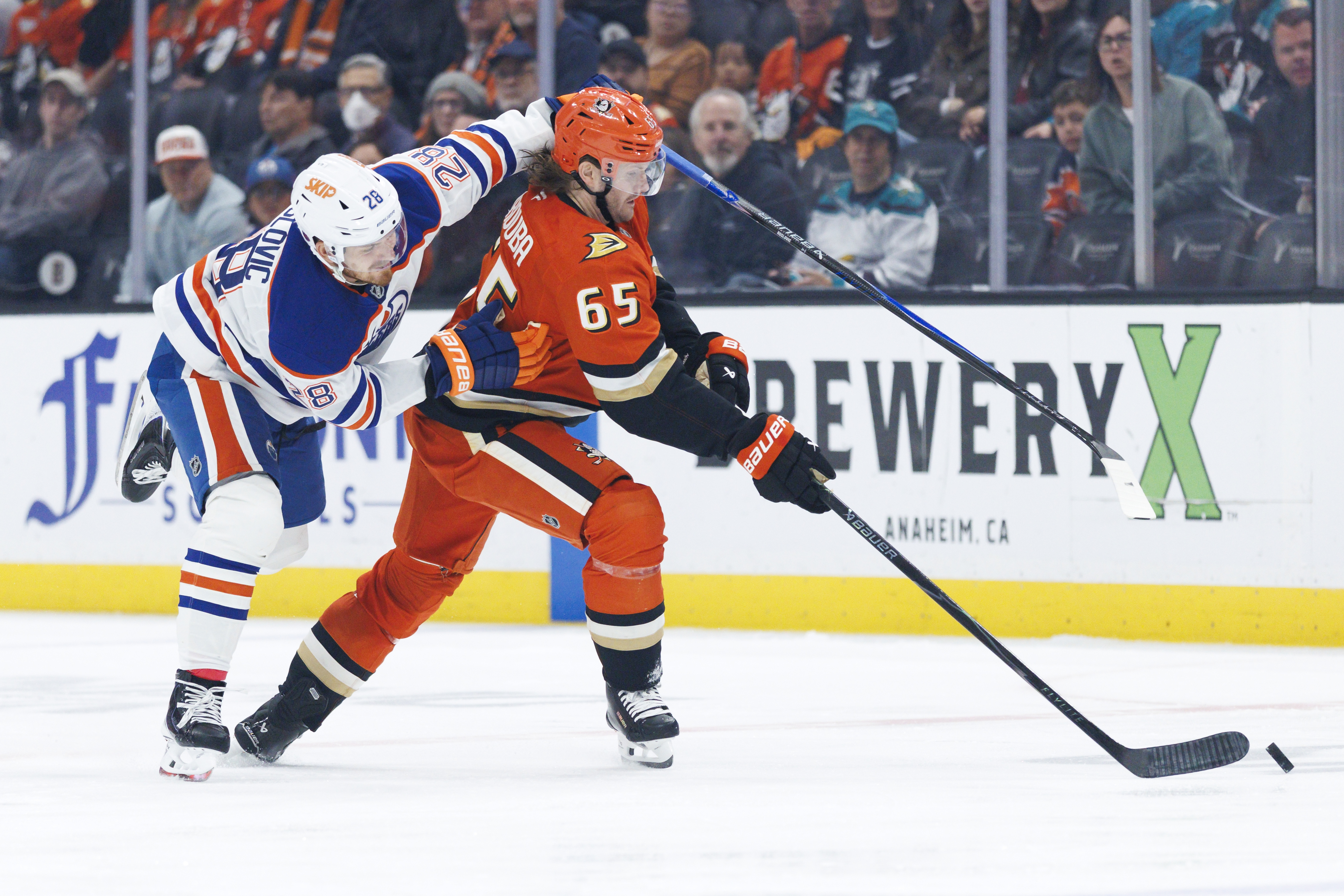 Ducks defenseman Jacob Trouba, right, skates with the puck as...