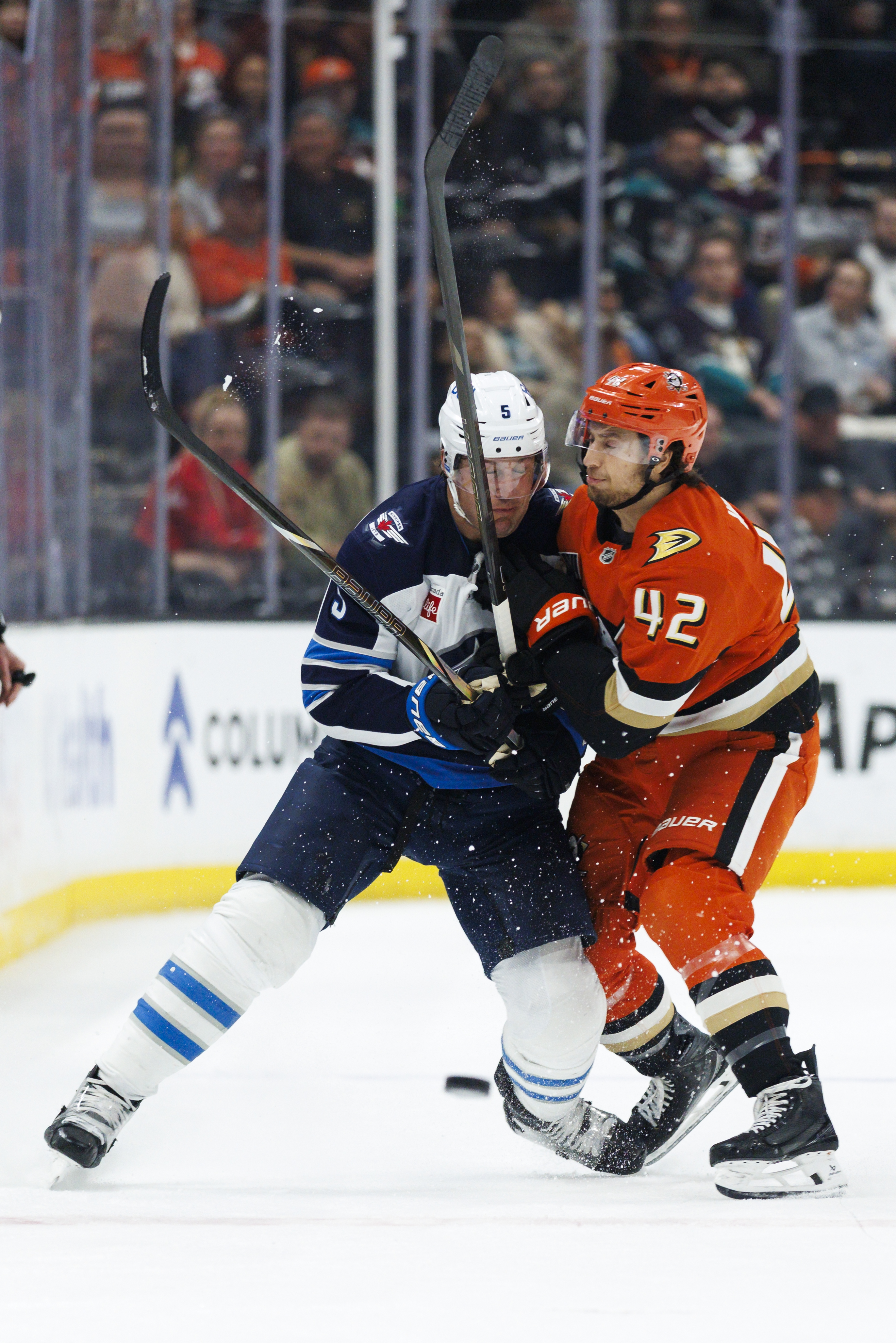 The Ducks’ Tim Washe, right, checks the Winnipeg Jets’ Luke...