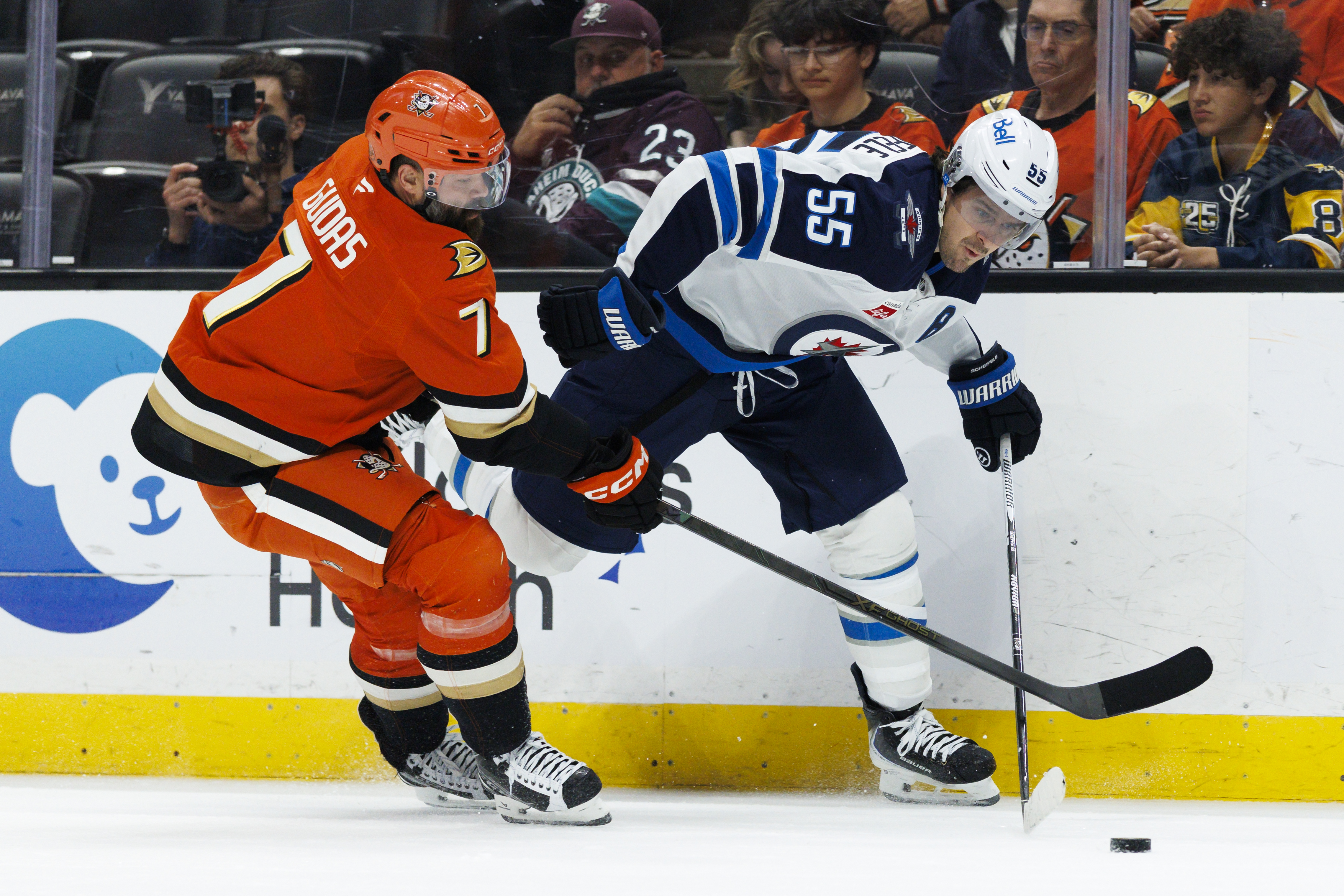 The Winnipeg Jets’ Mark Scheifele, right, skates with the puck...