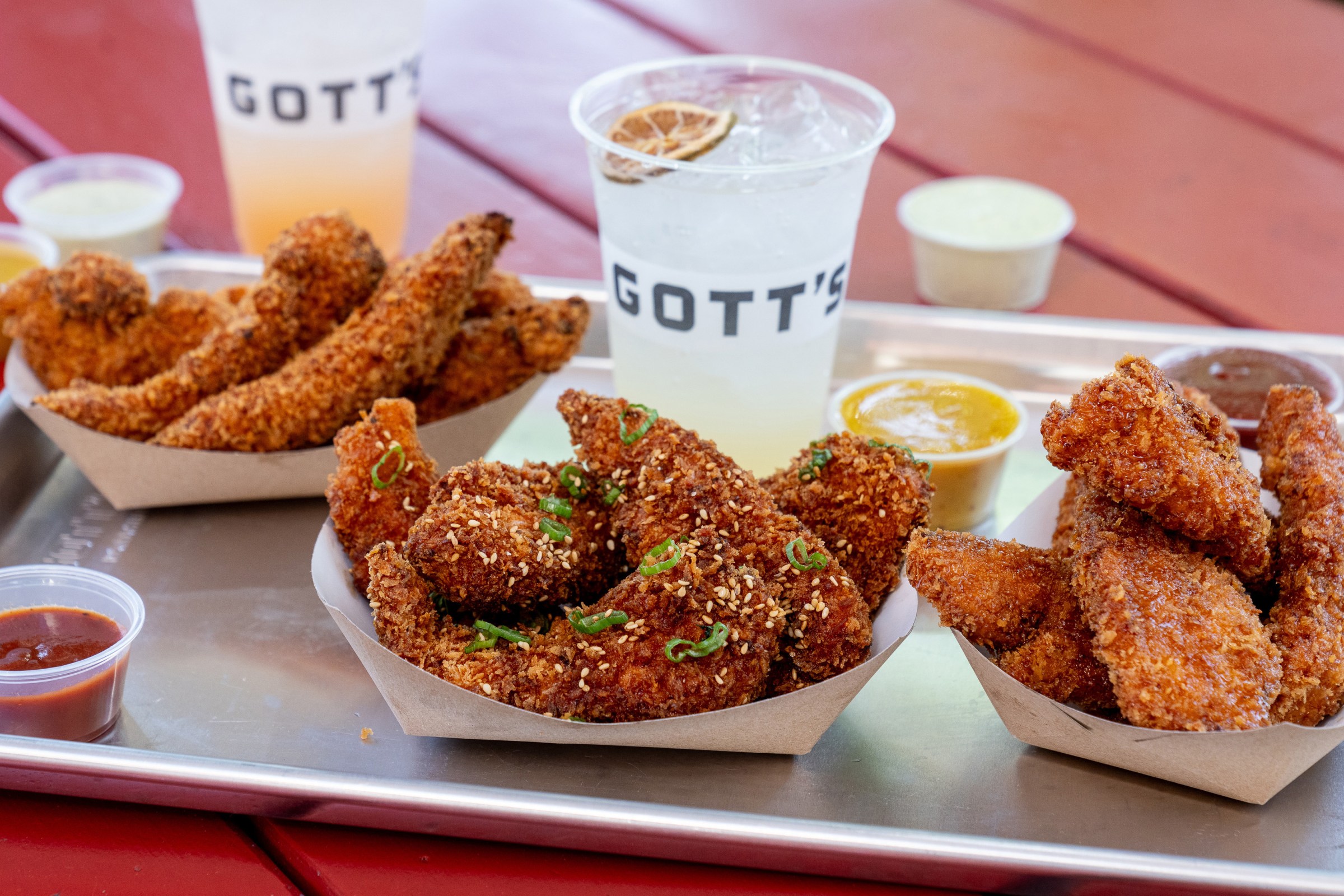 Three paper boats of chicken tenders on a metal tray at Gott’s.