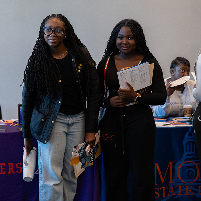two event attendees standing together smiling