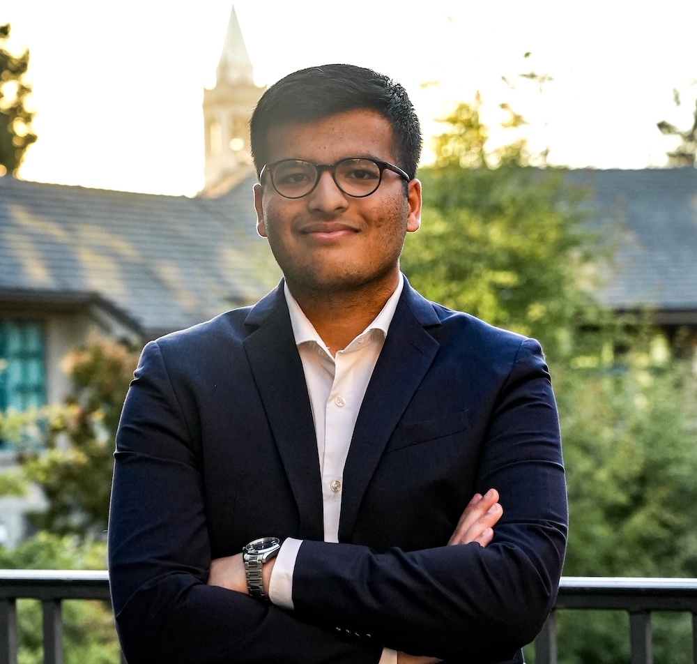 man wearing a suit and glasses with arms folded