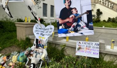Memorial tribute with photographs and toys commemorating a father and child.