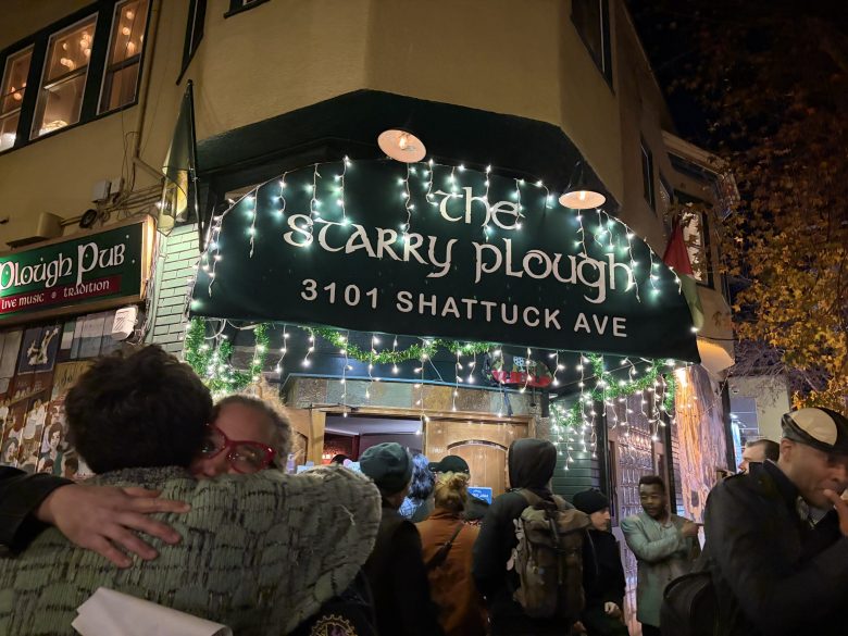 People gather outside Irish pub Starry Plough in Berkeley whose awning is lit up with holiday lights