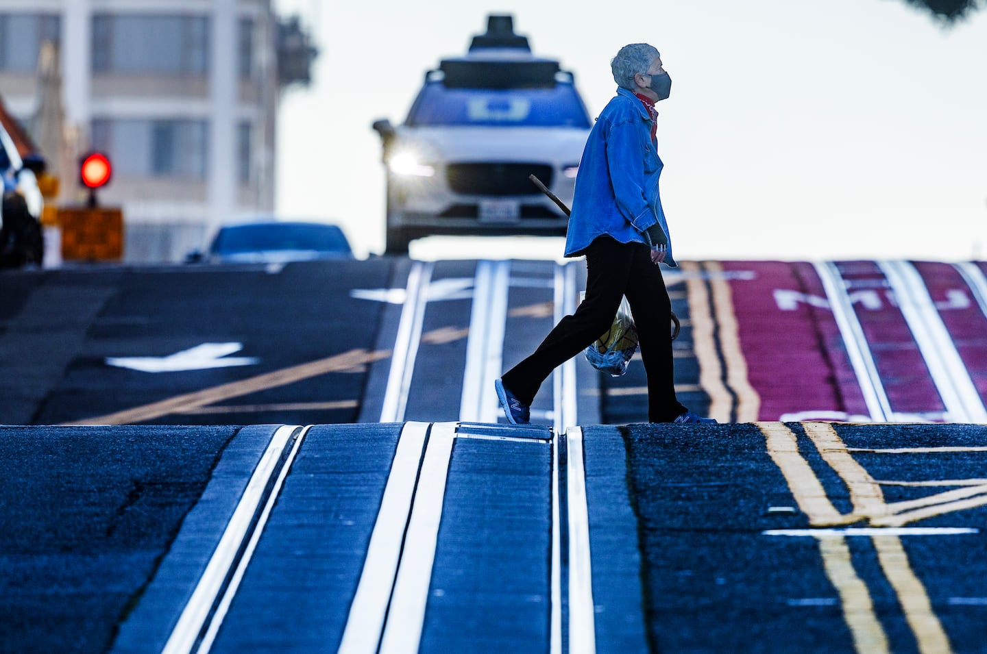 A Waymo heads down a hill as its sensors pick up a pedestrian.