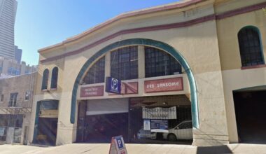 A two-story parking garage at 825 Sansome Street with signs for monthly parking and daily parking available; a sidewalk sandwich board advertises parking for $25.