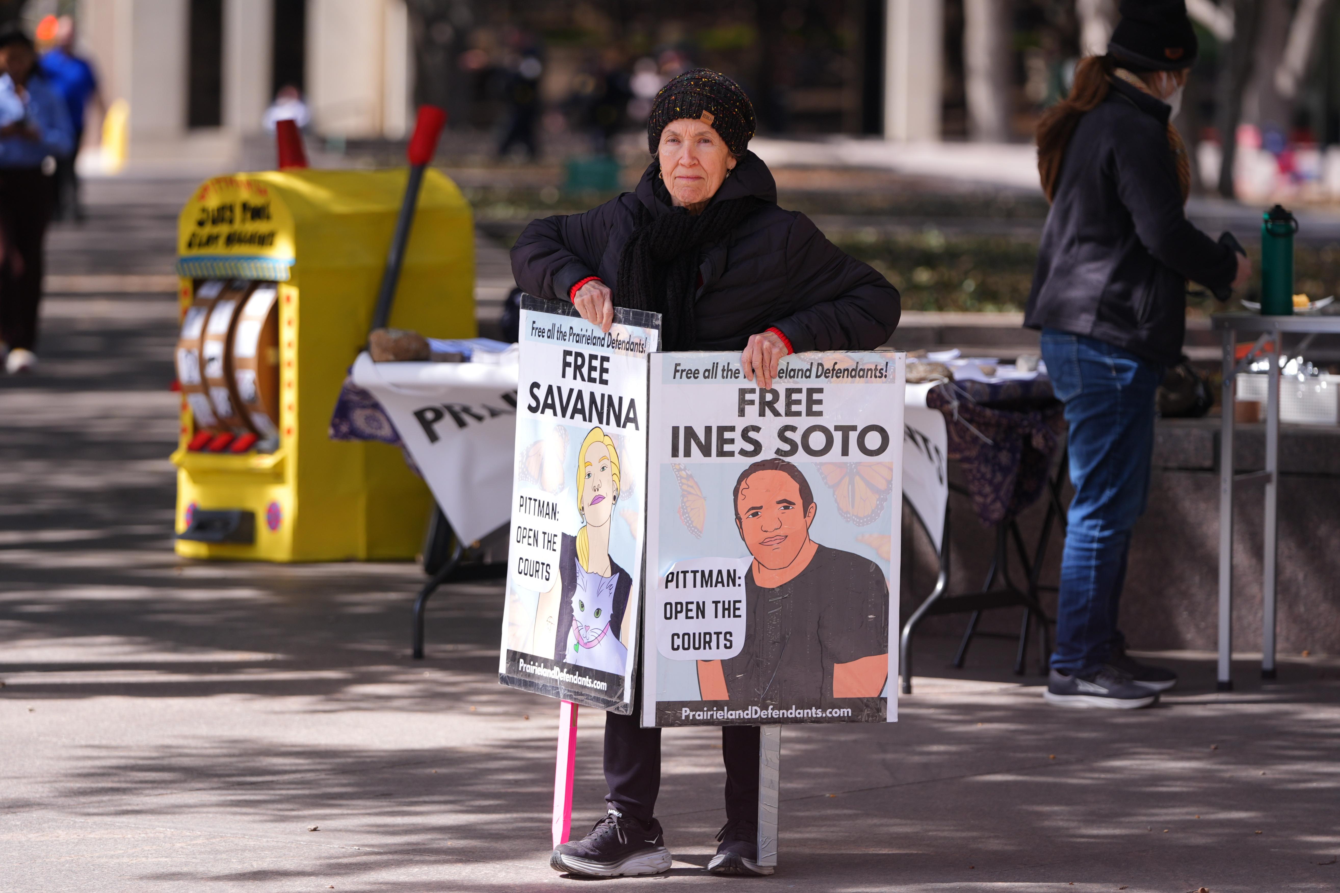 usan Oakey holds a sign across the street from the Eldon B. Mahon U.S. Courthouse.