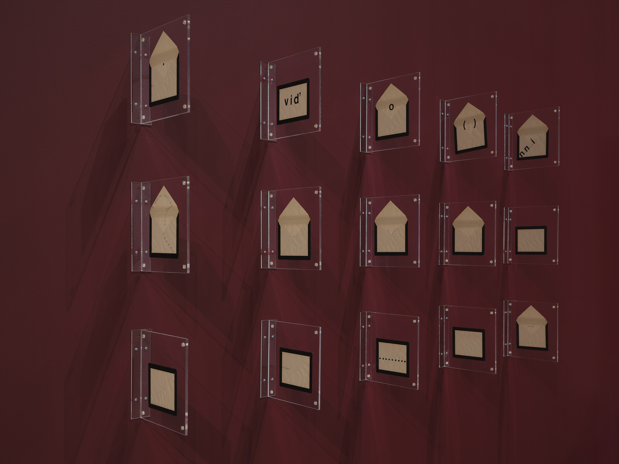 thick black edged envelopes mounted sticking out from burgundy wall