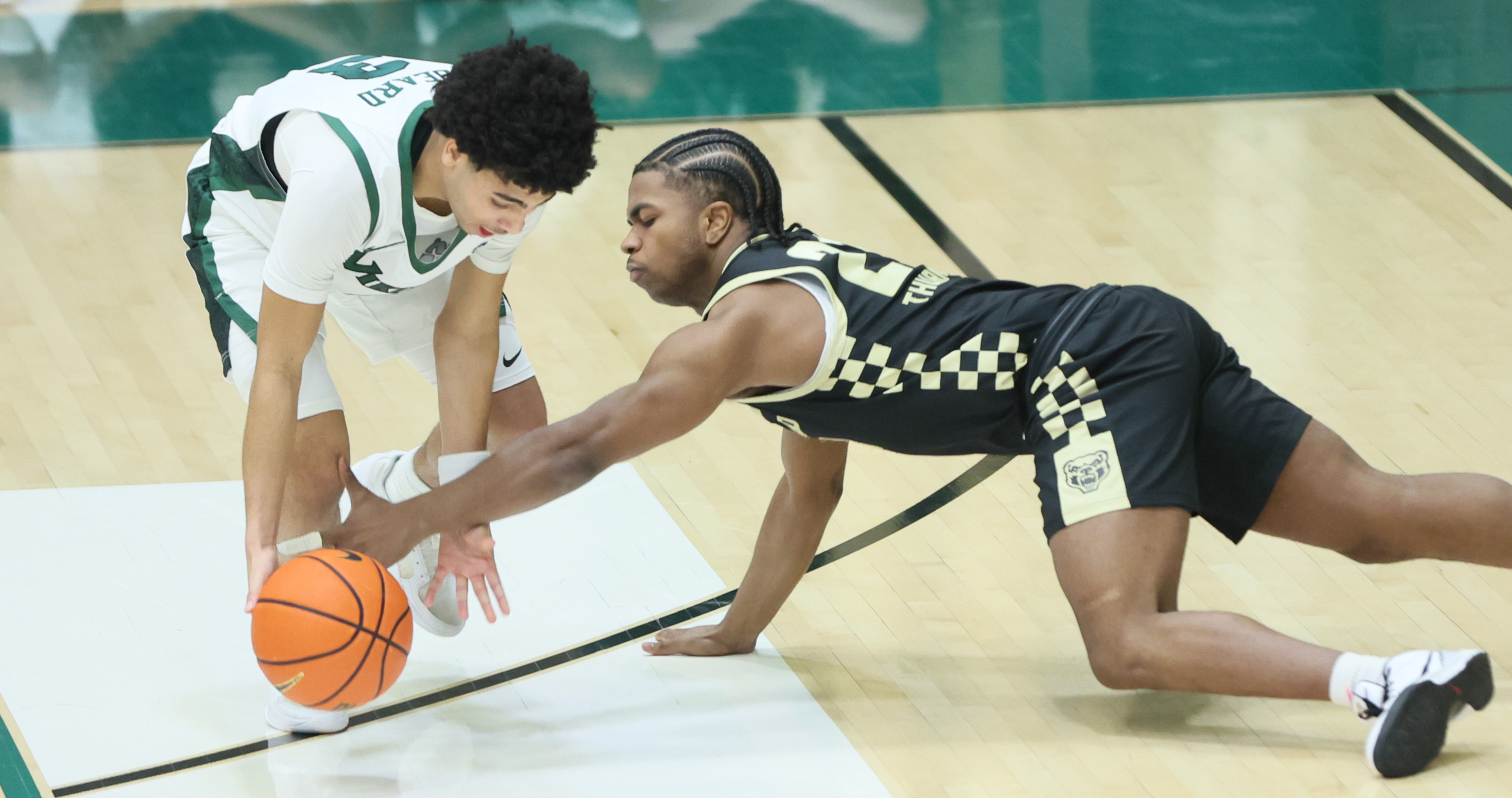 Oakland Golden Grizzlies guard Khoi Thurmon makes a diving steal attempt on the dribble of Cleveland State Vikings guard Tre Beard in the second half.  