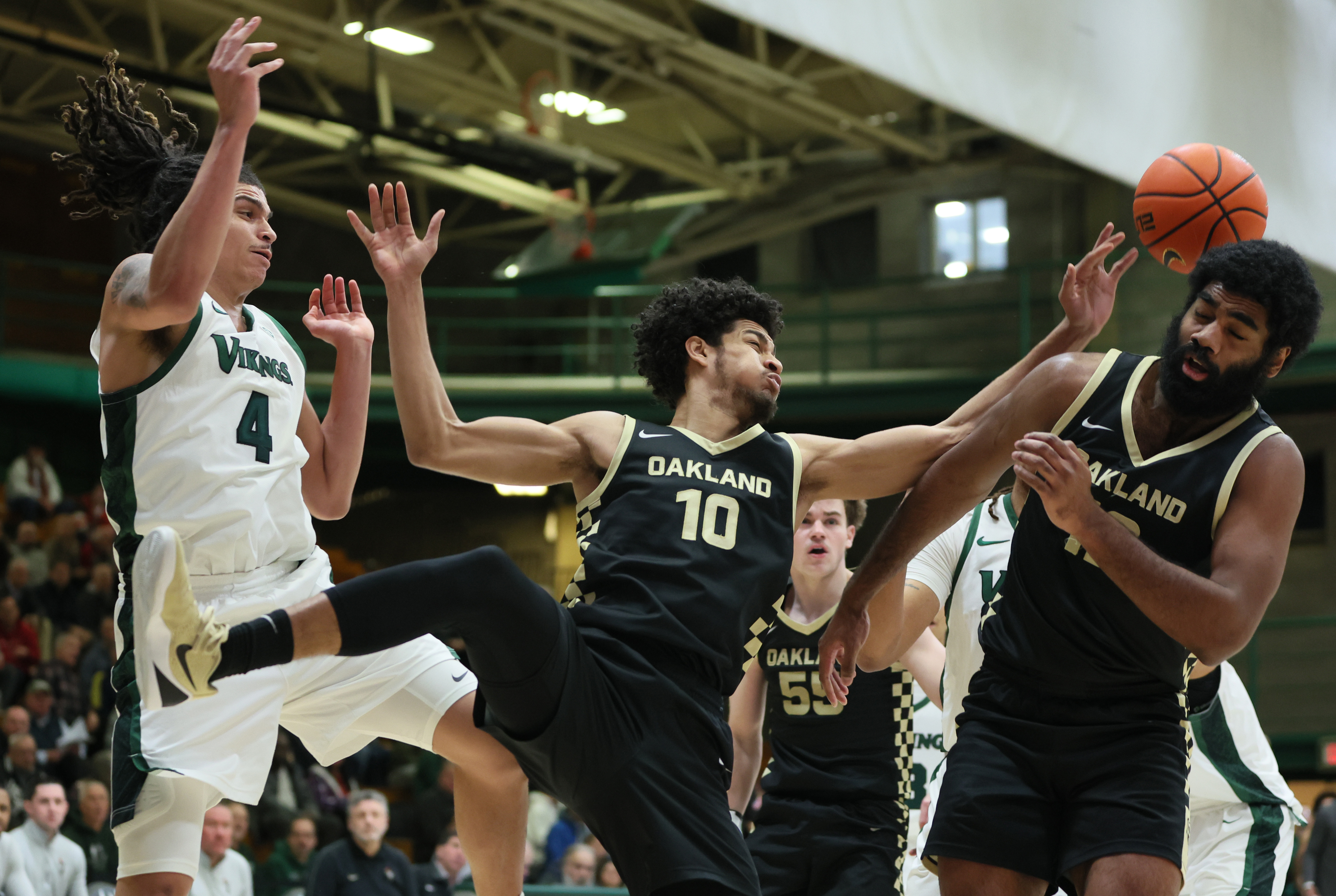 Cleveland State Vikings forward Preist Ryan (L) and Oakland Golden Grizzlies guard Brett White (C) and Oakland Golden Grizzlies forward Tuburu Naivalurua battle for possession of a rebound in the first half.