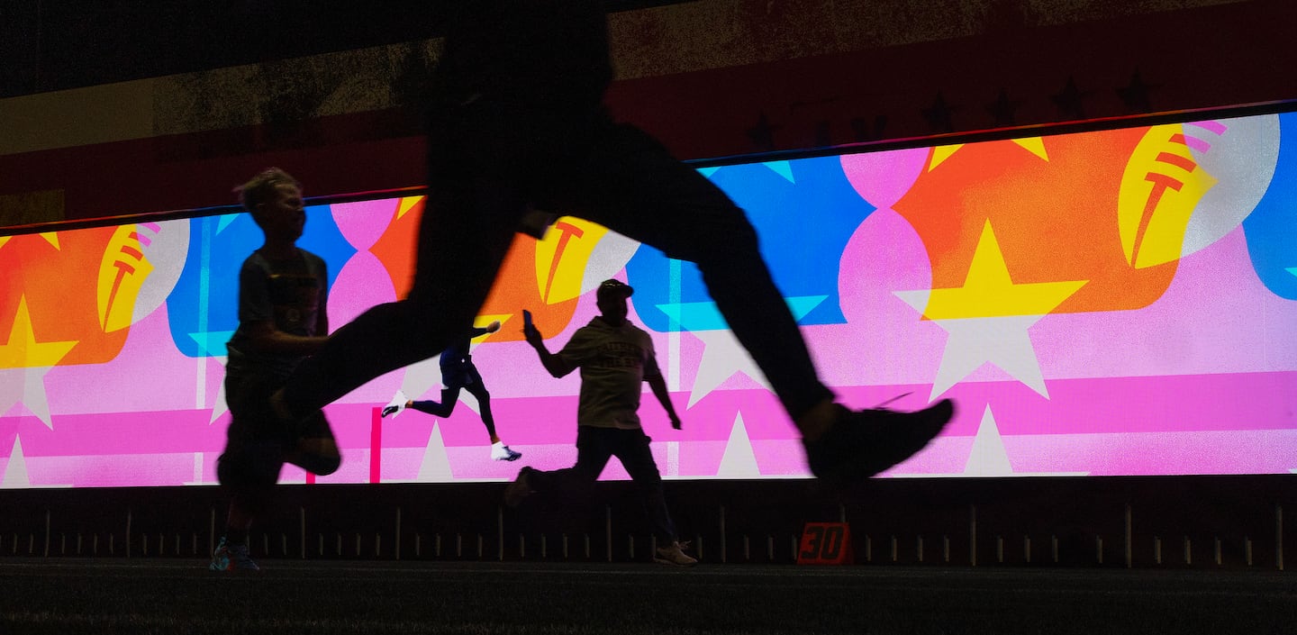 A dad films his kid while also competing in a timed 40 yard dash, before the Super Bowl in San Francisco.
