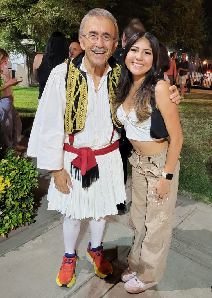 Kopi Sotiropulos, in his Greek garb, poses with a fan