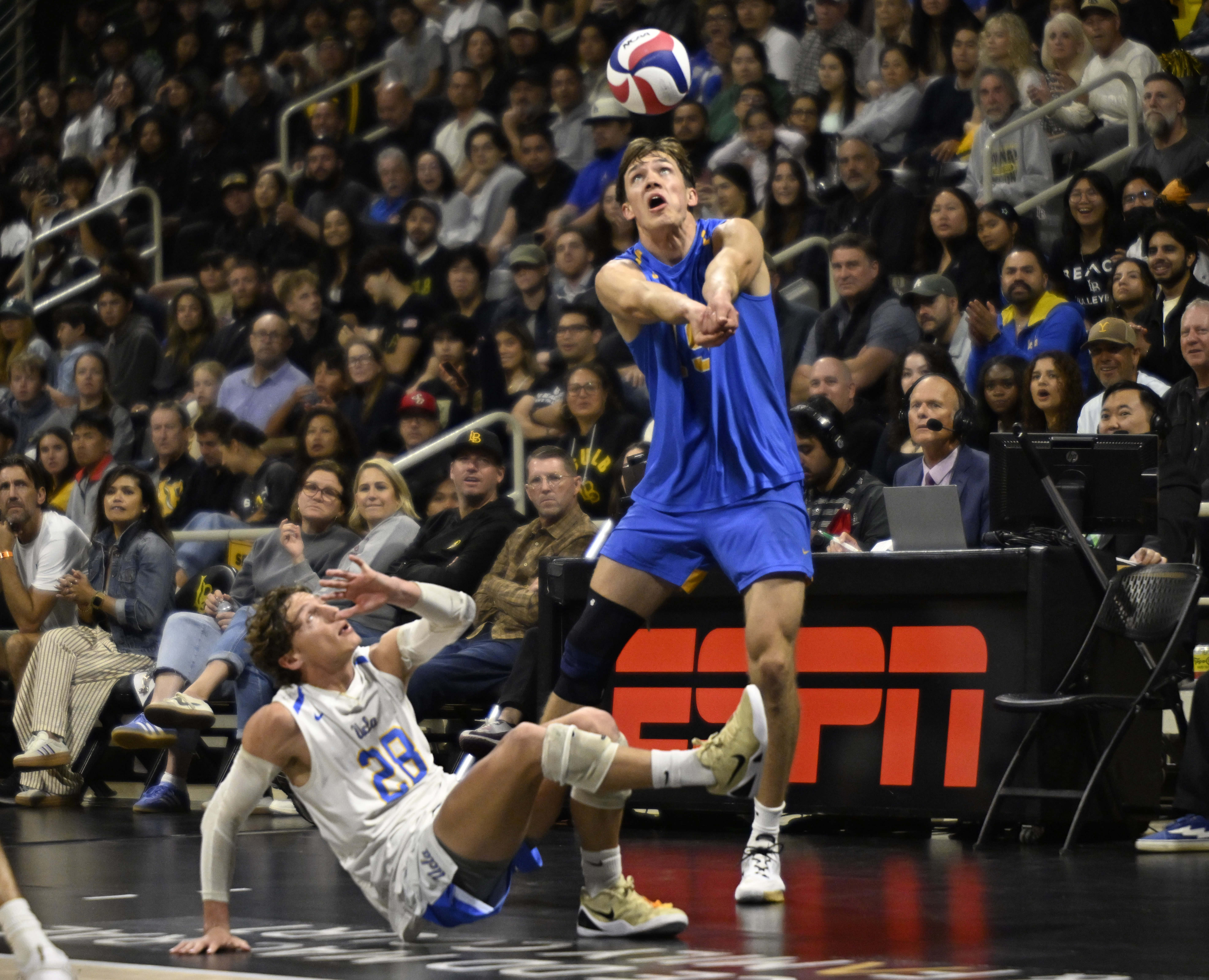 UCLA opposite David Decker, right, returns a shot as libero...