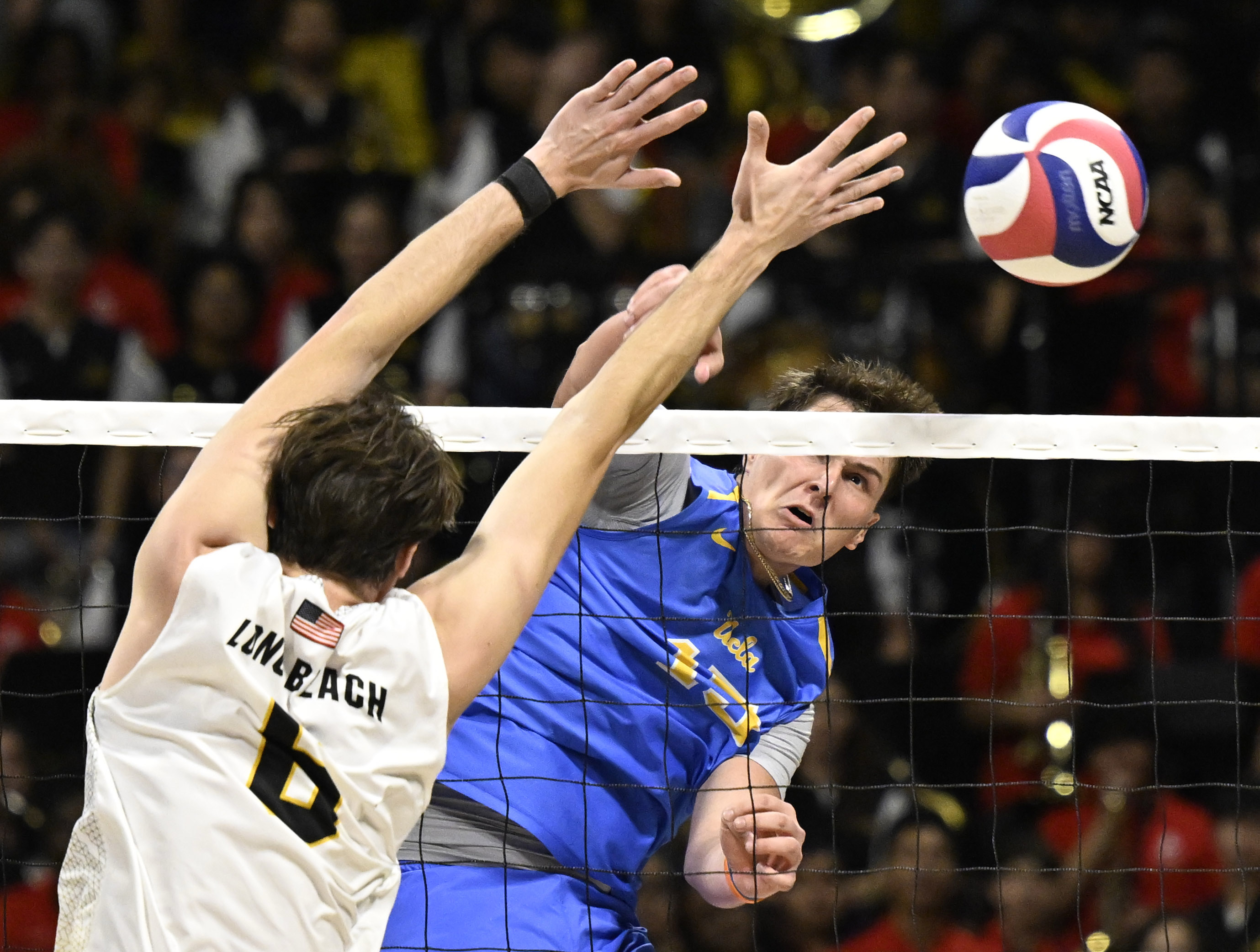UCLA middle blocker Christopher Hersh, right, sends a kill past...