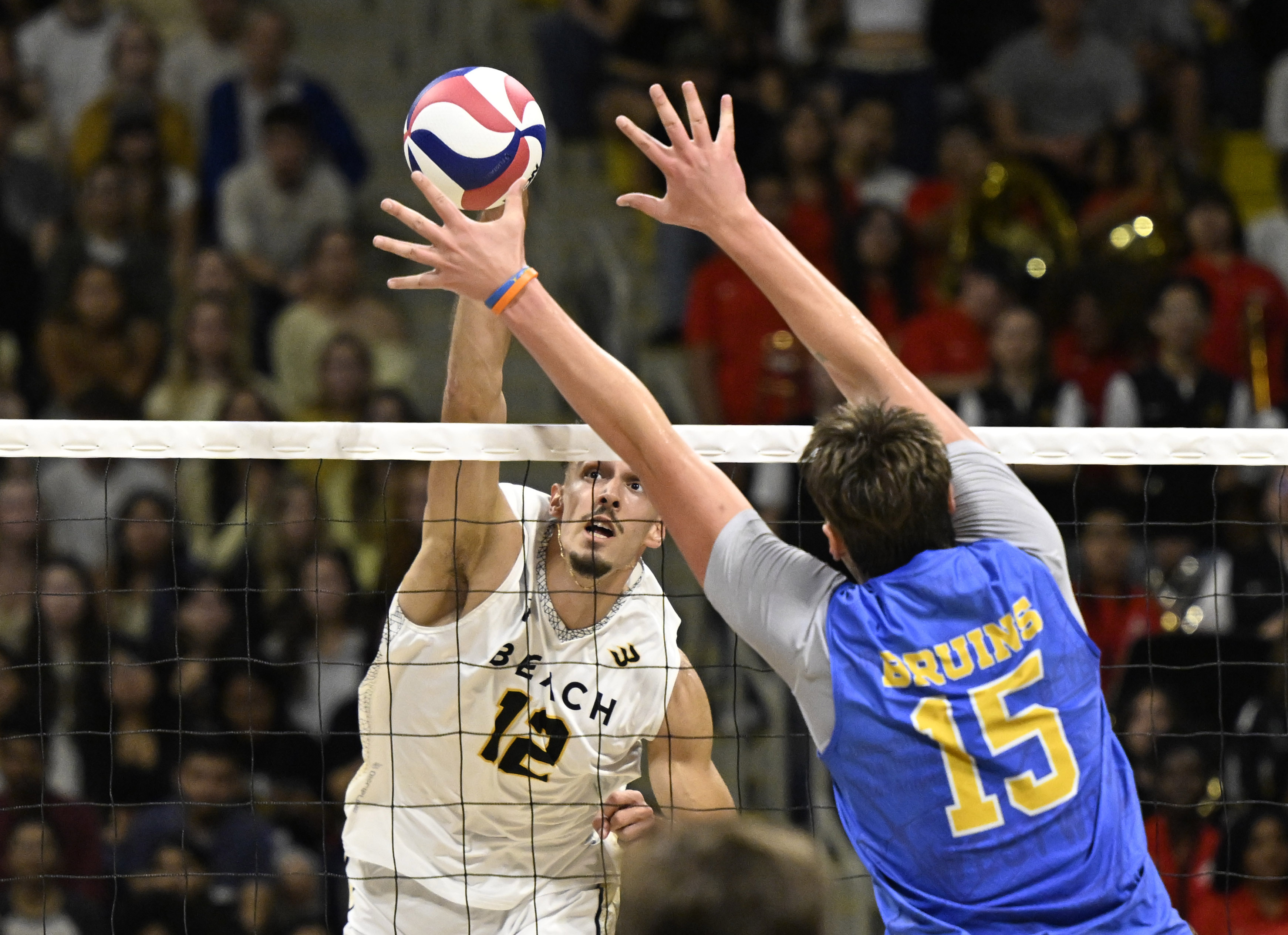 Long Beach State outside hitter Alex Kandev, left, hits as...
