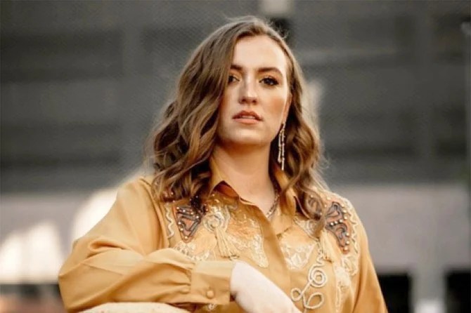 A young woman poses wearing a Western-style embroidered shirt