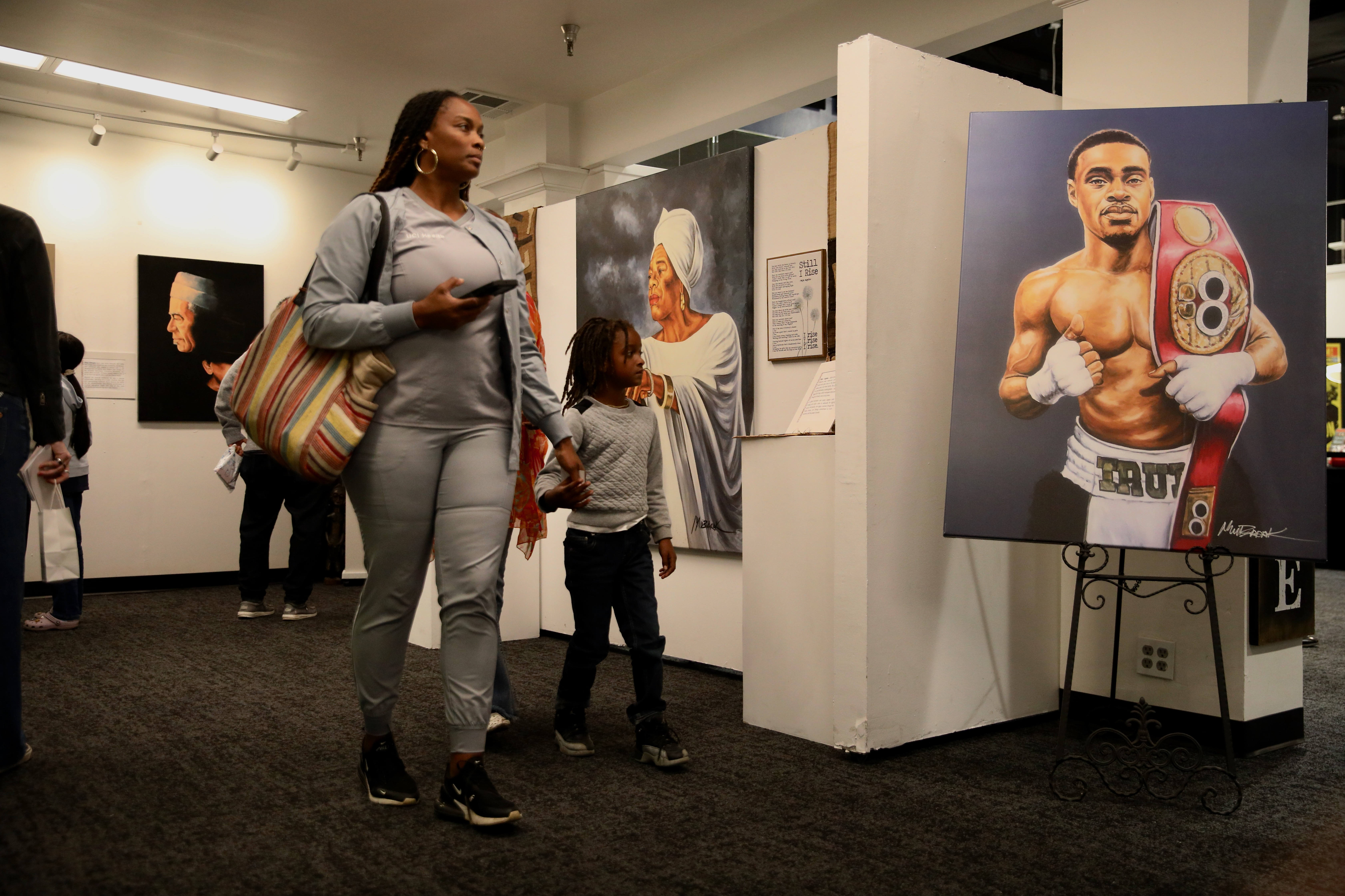 Attendees walk through a photo exhibit at a Black History...