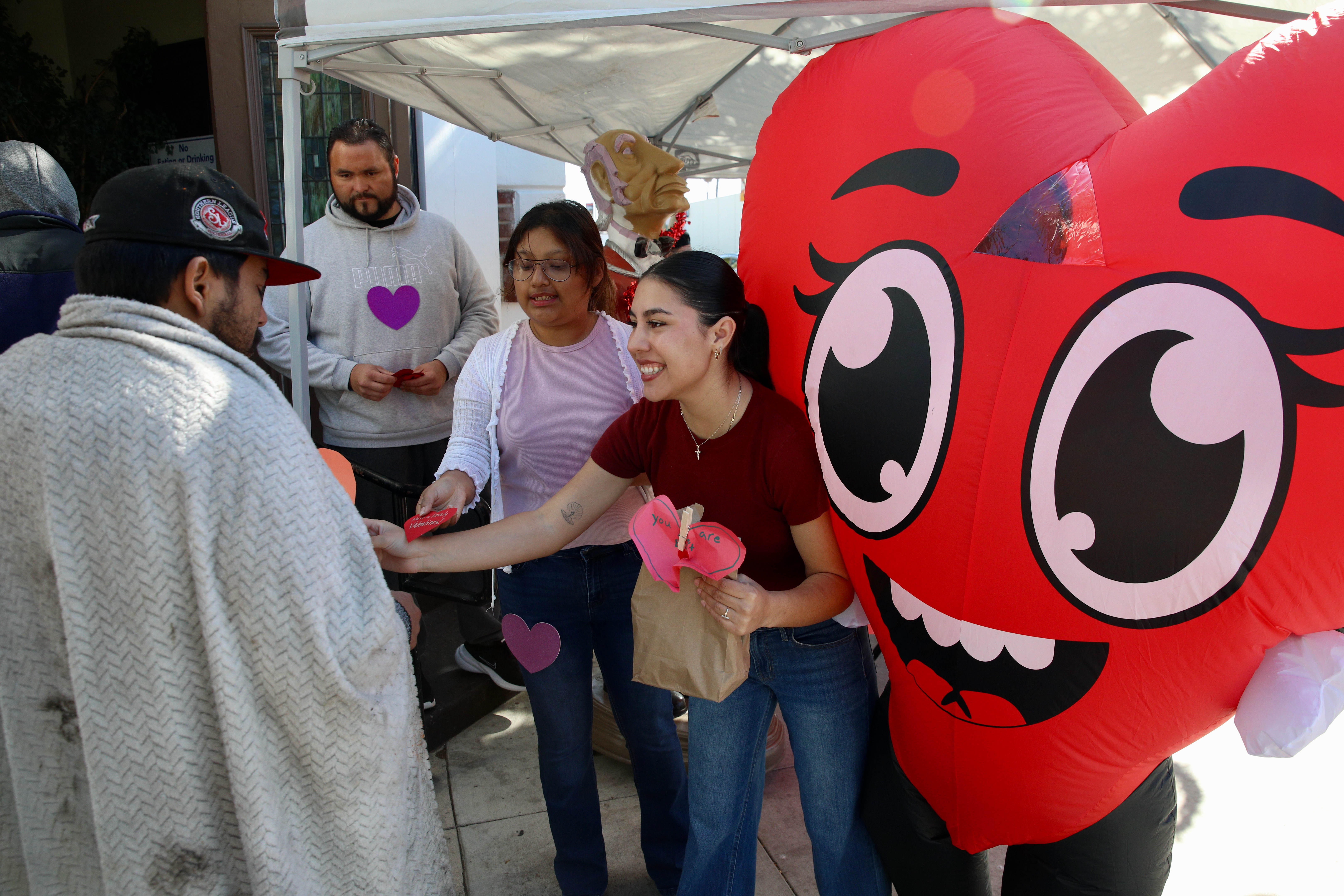 Volunteers from Christian Outreach in Action hand members of the...