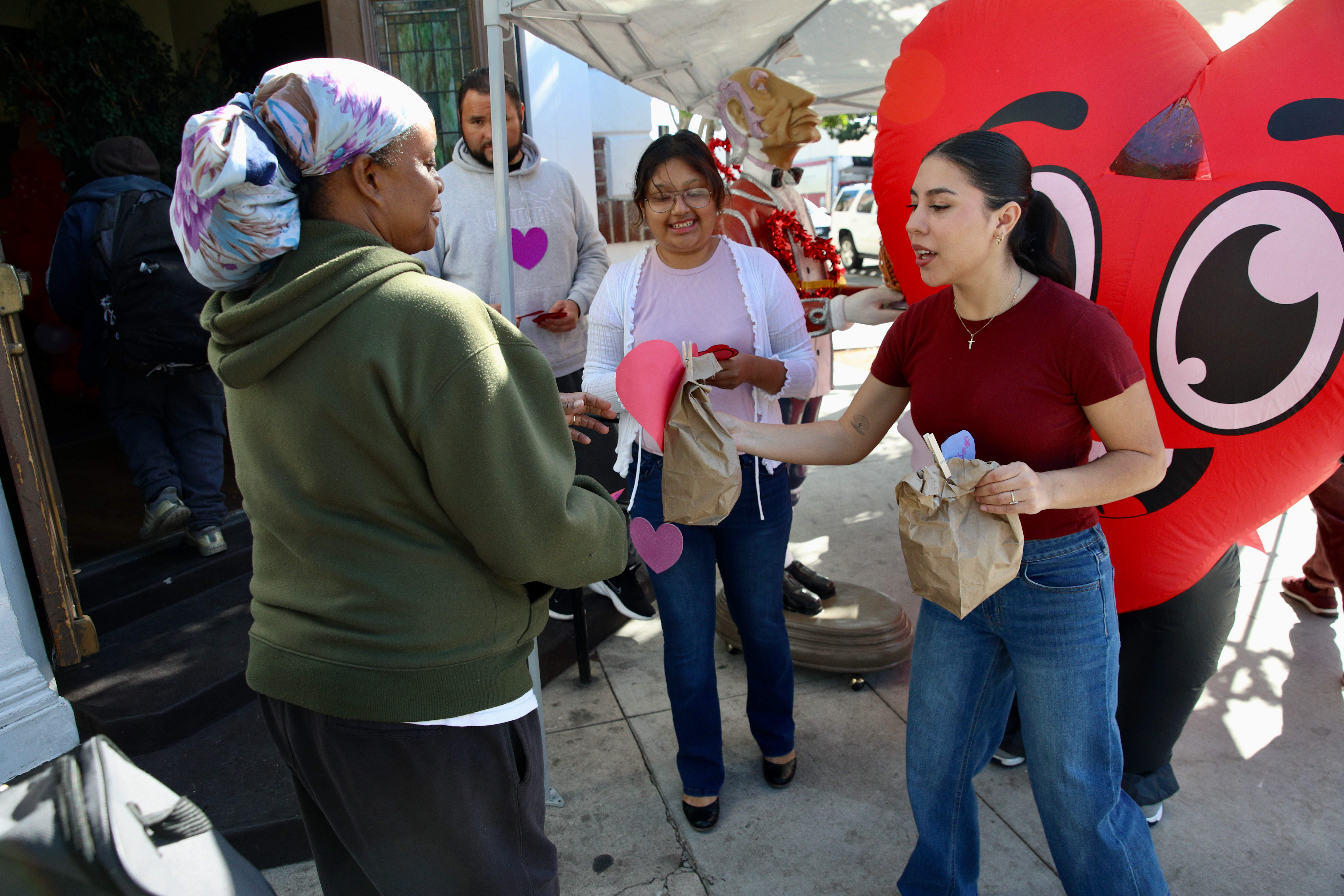 Volunteers from Christian Outreach in Action hand members of the...