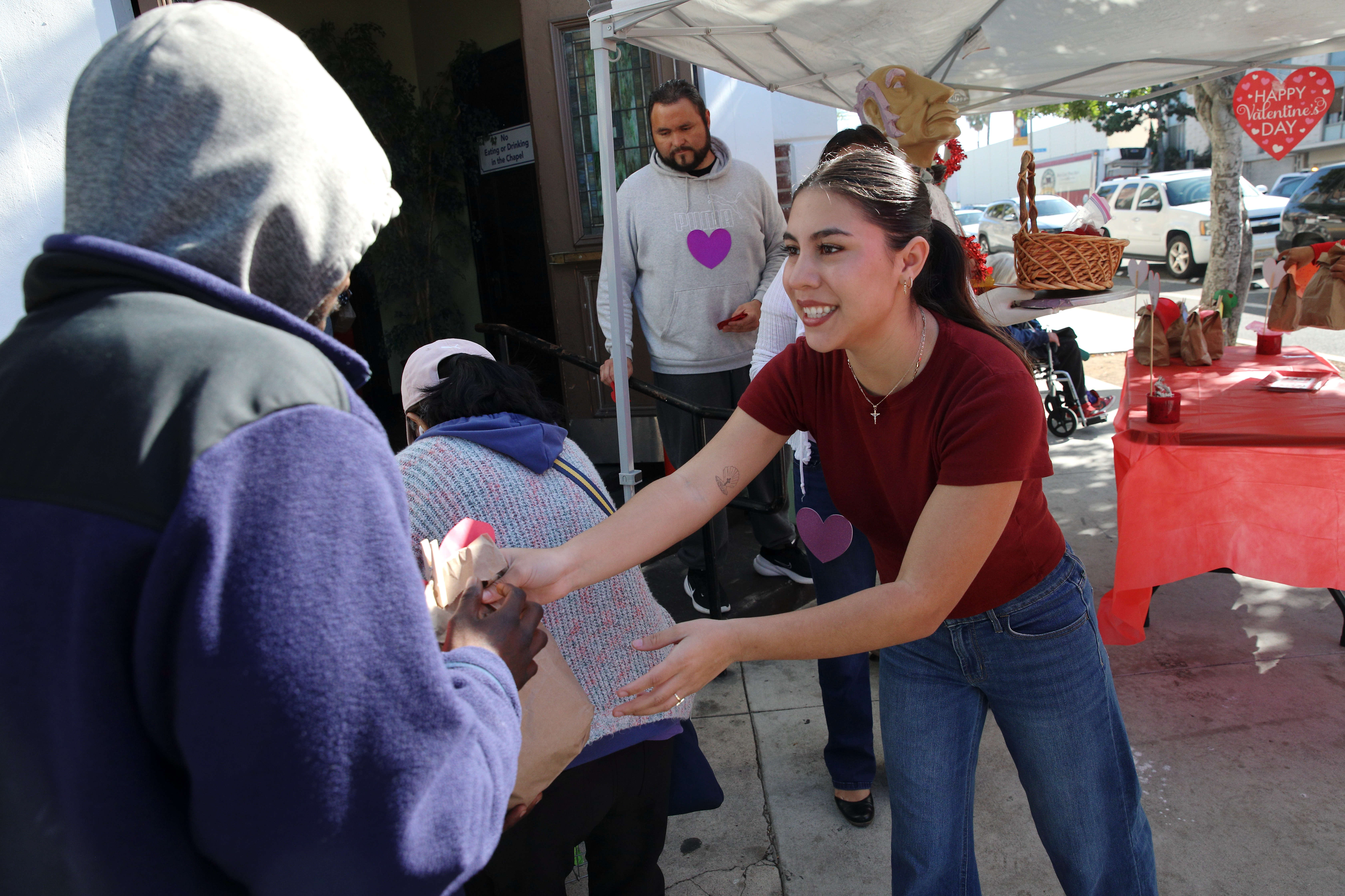 A volunteer from Christian Outreach in Action hands out goodie...