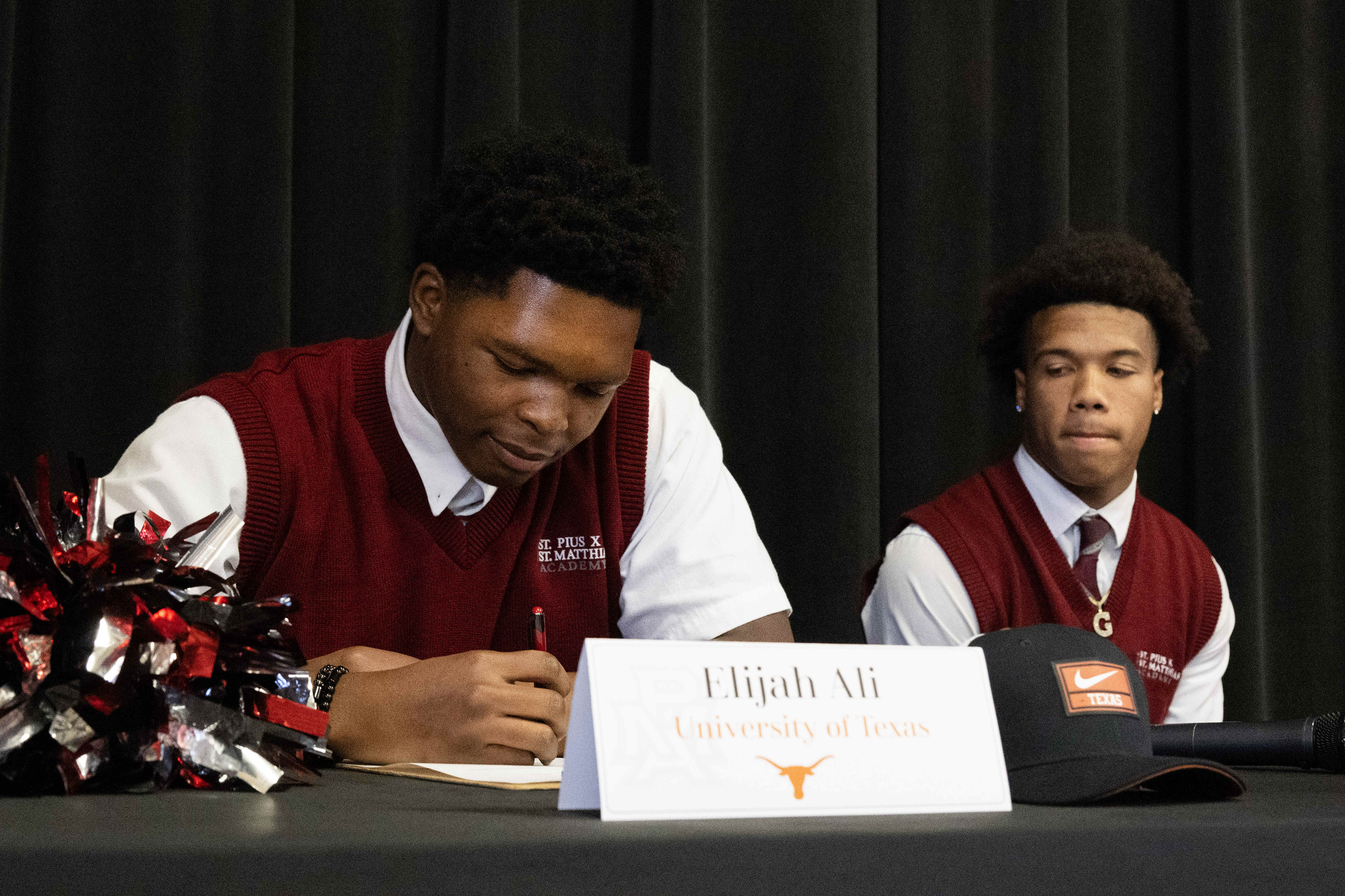 Elijah Ali, left, signs his commitment to the University of...