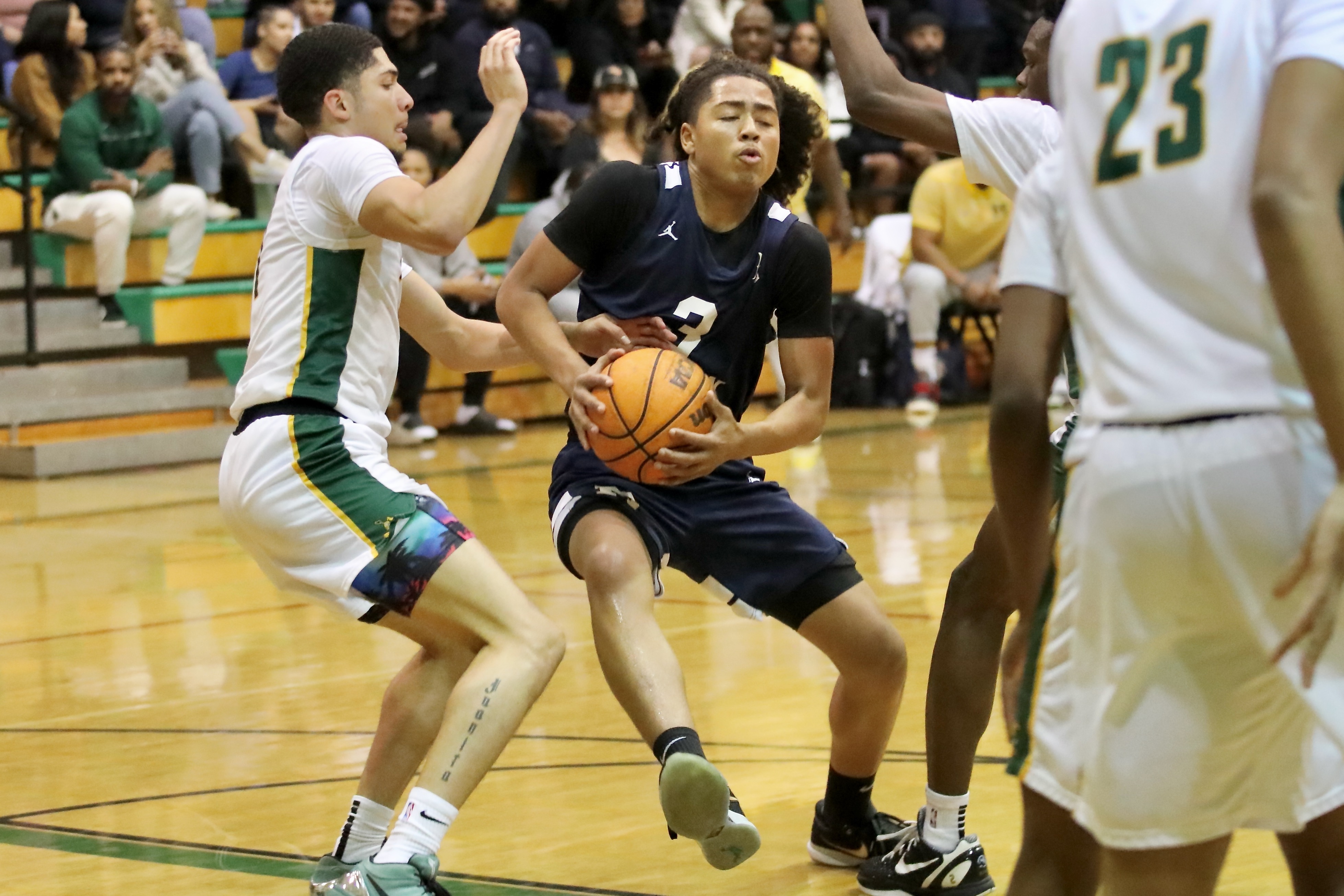 Millikanâs Joseph Wicker (3) is tightly defended by Polyâs Jovani...