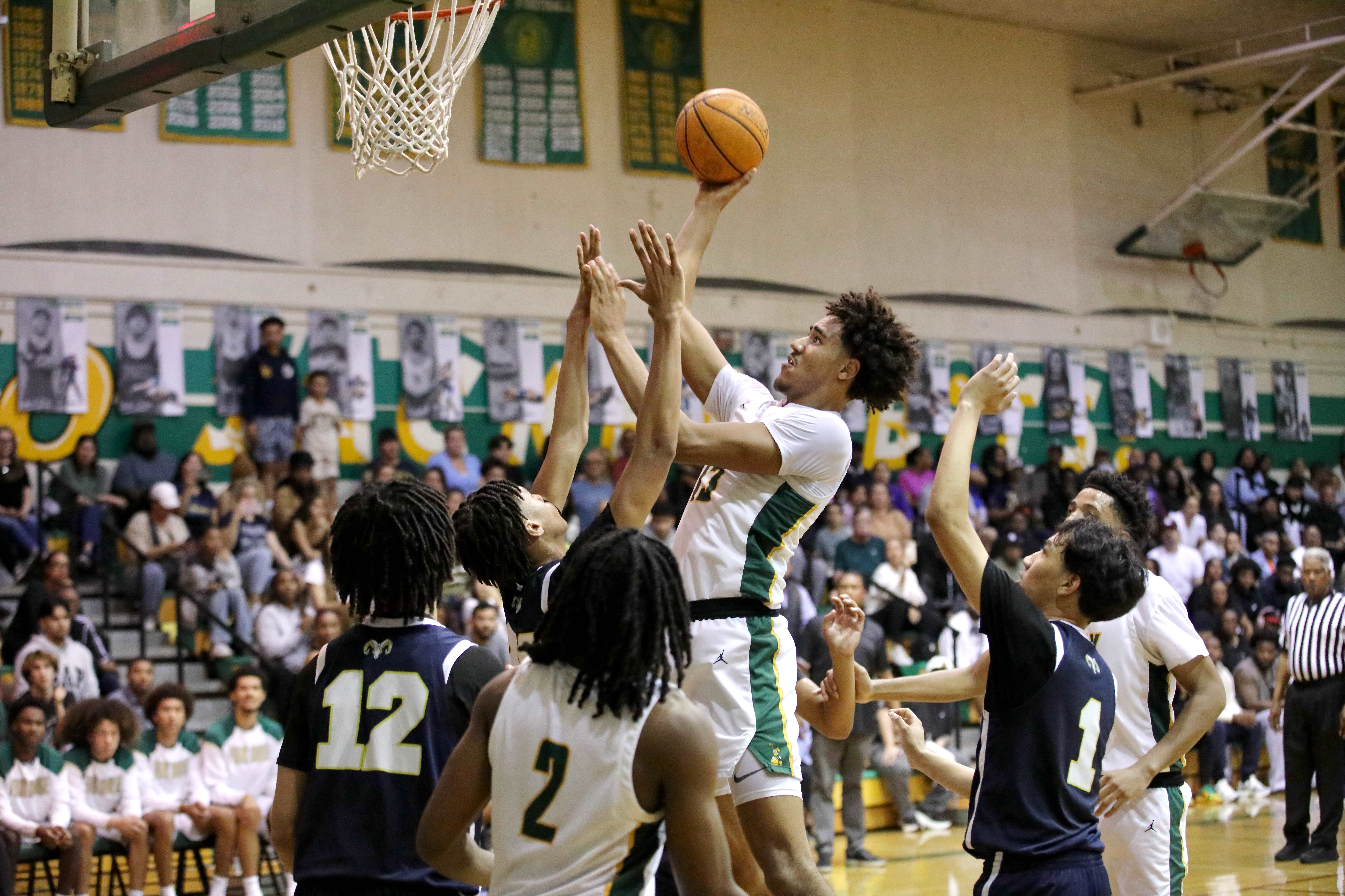 Long Beach Poly senior center Jonas Oware scores a basket...