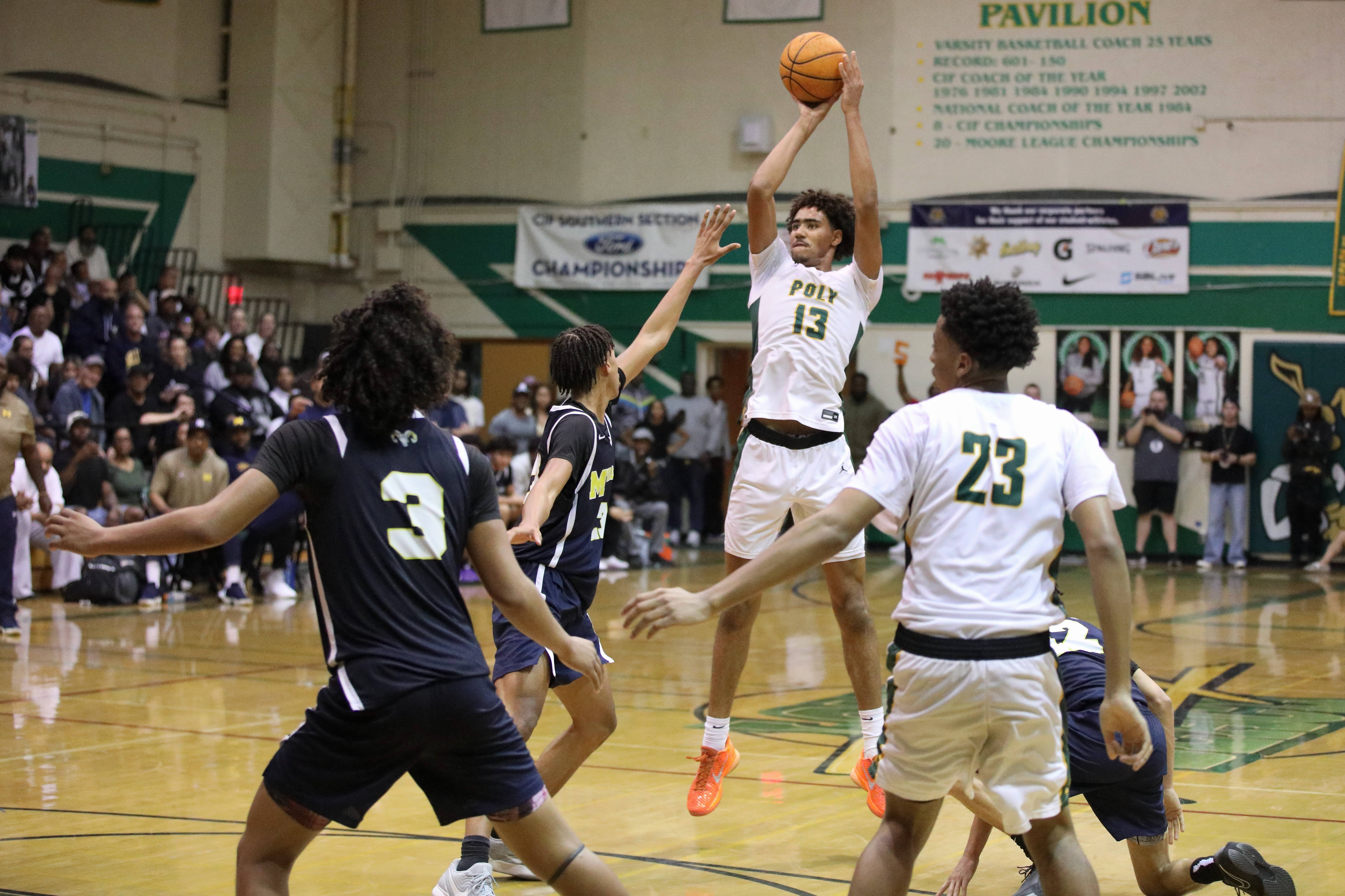 Long Beach Poly senior center Jonas Oware takes a jump...