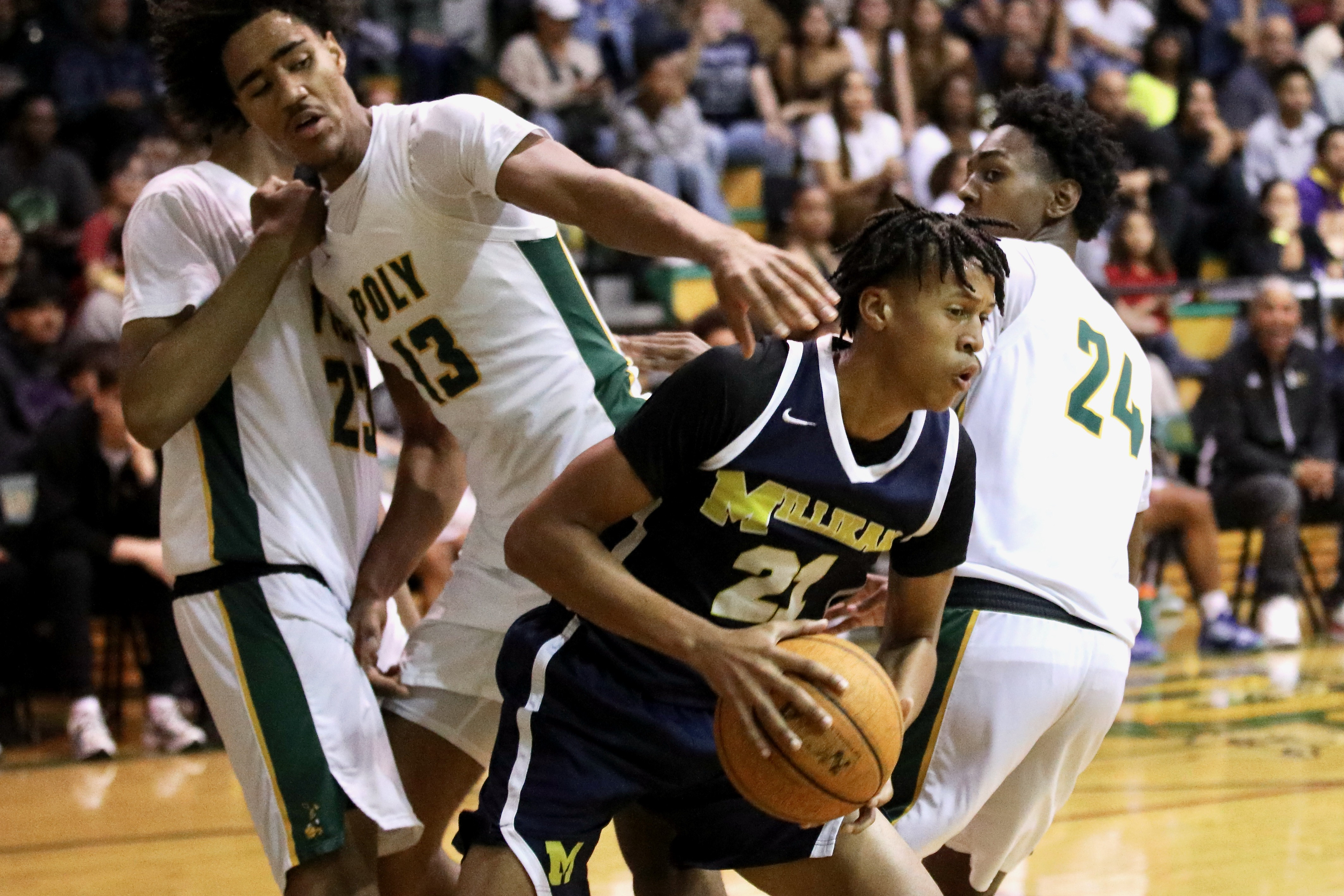 Millikan junior Christian Parron collects a rebound in Moore League...