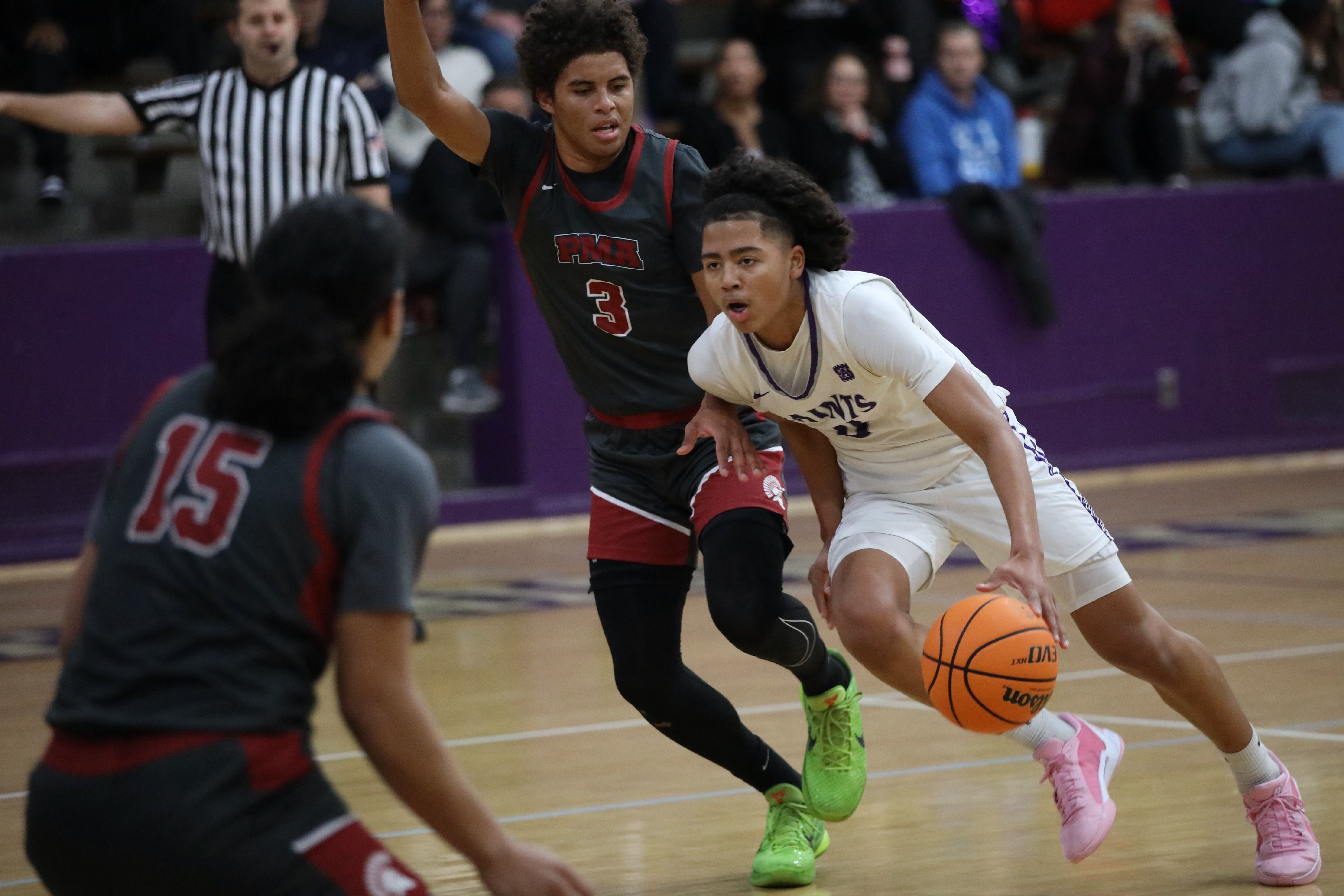 St. Anthony sophomore guard JoJo Wicker drives past a pair...