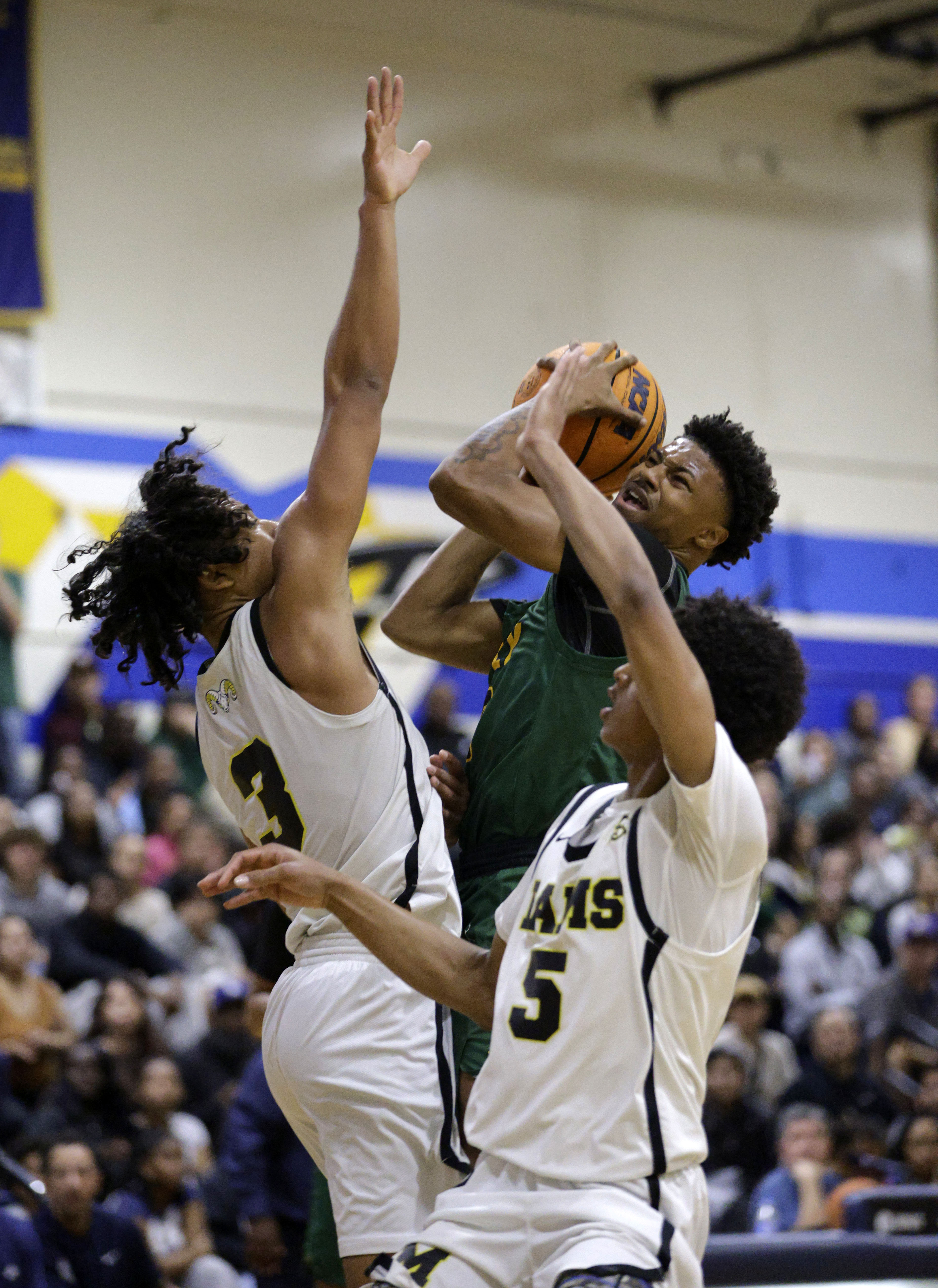Millikan’s Joseph Wicker (3) and Quali Giran (5) try to...