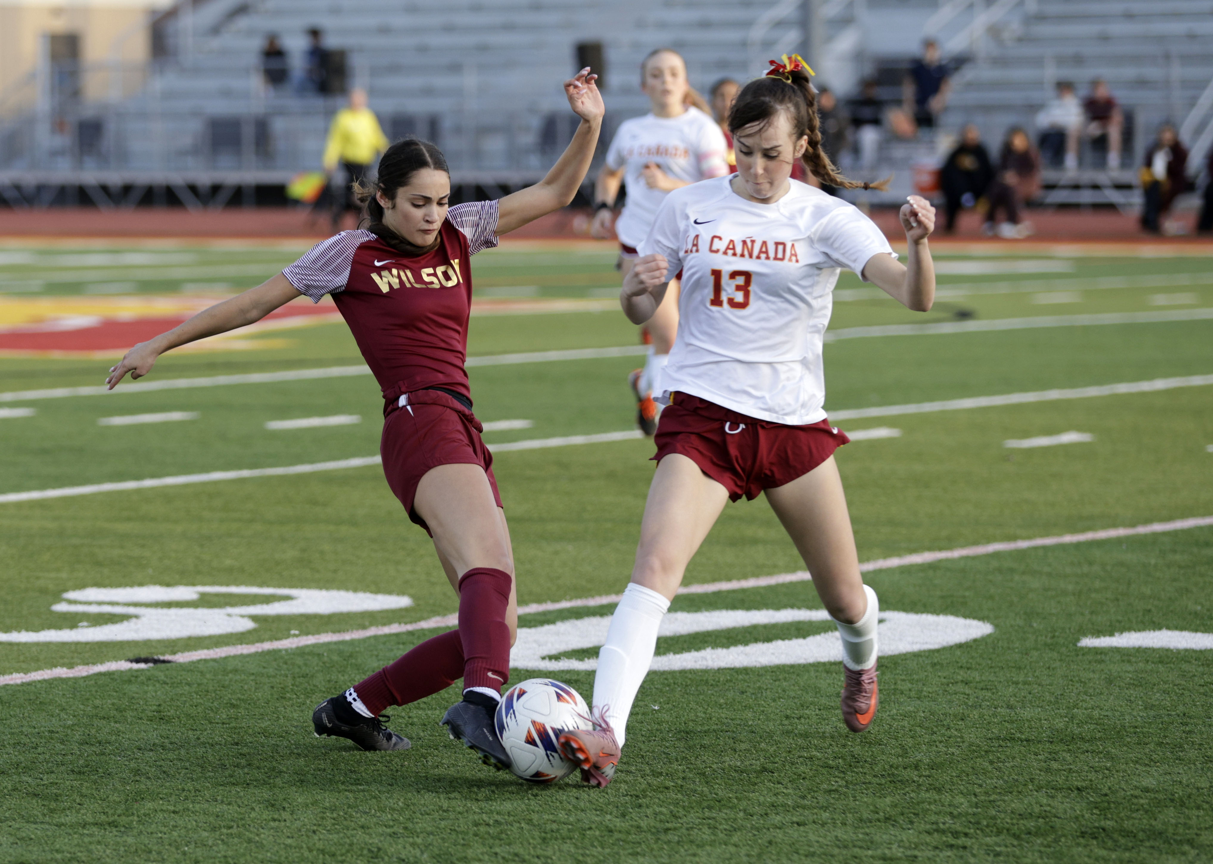 Wilson’s Evan Cassidy (3) and La Canada’s Juliette Evans (13)...