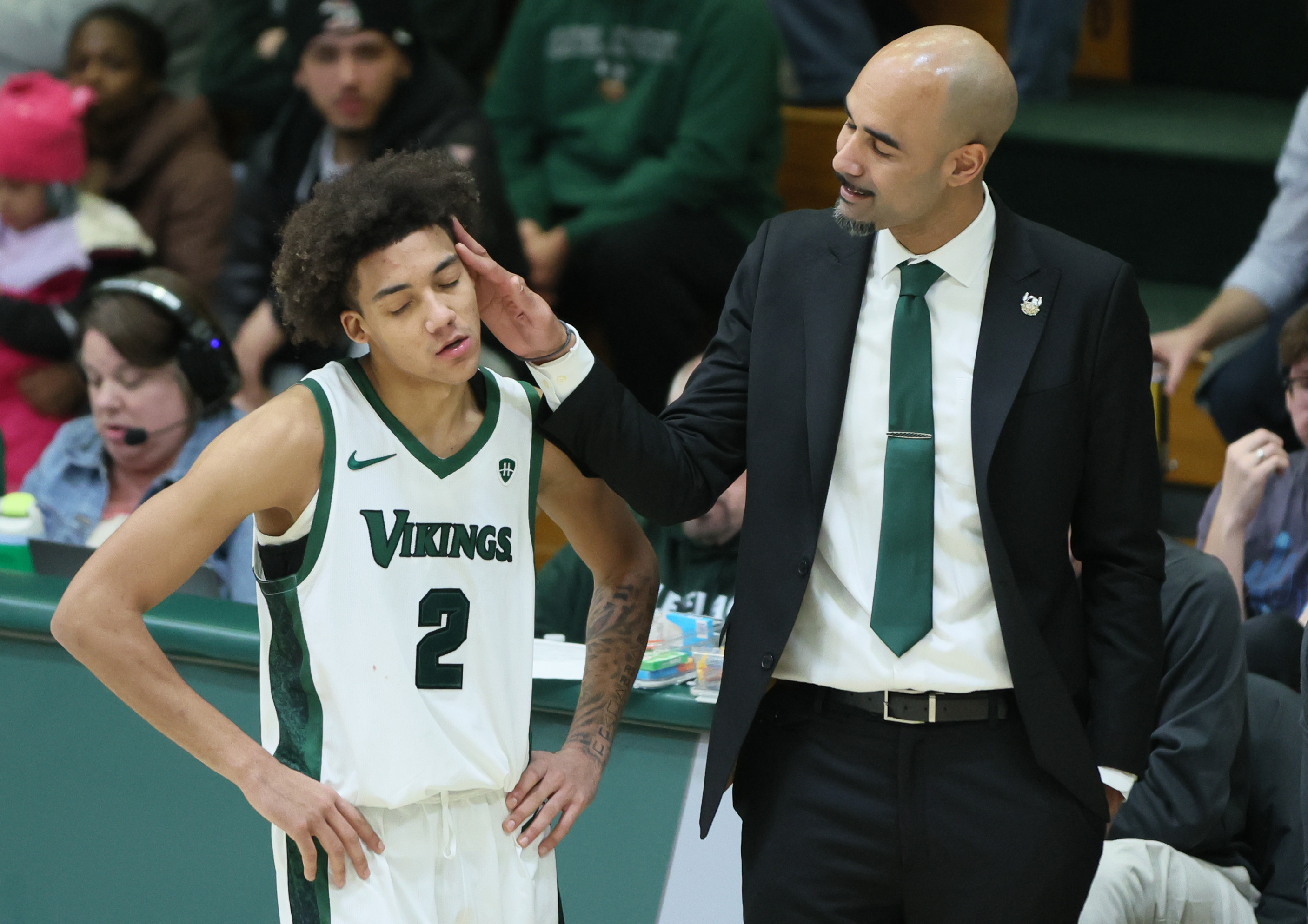 Cleveland State Vikings head coach Rob Summers playfully taps the head of Cleveland State Vikings guard Jaidon Lipscomb during a free throw as the Cleveland State Vikings take the lead against the Oakland Golden Grizzlies in the second half.  