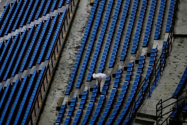 A worker cleans the seats at San Siro Stadium