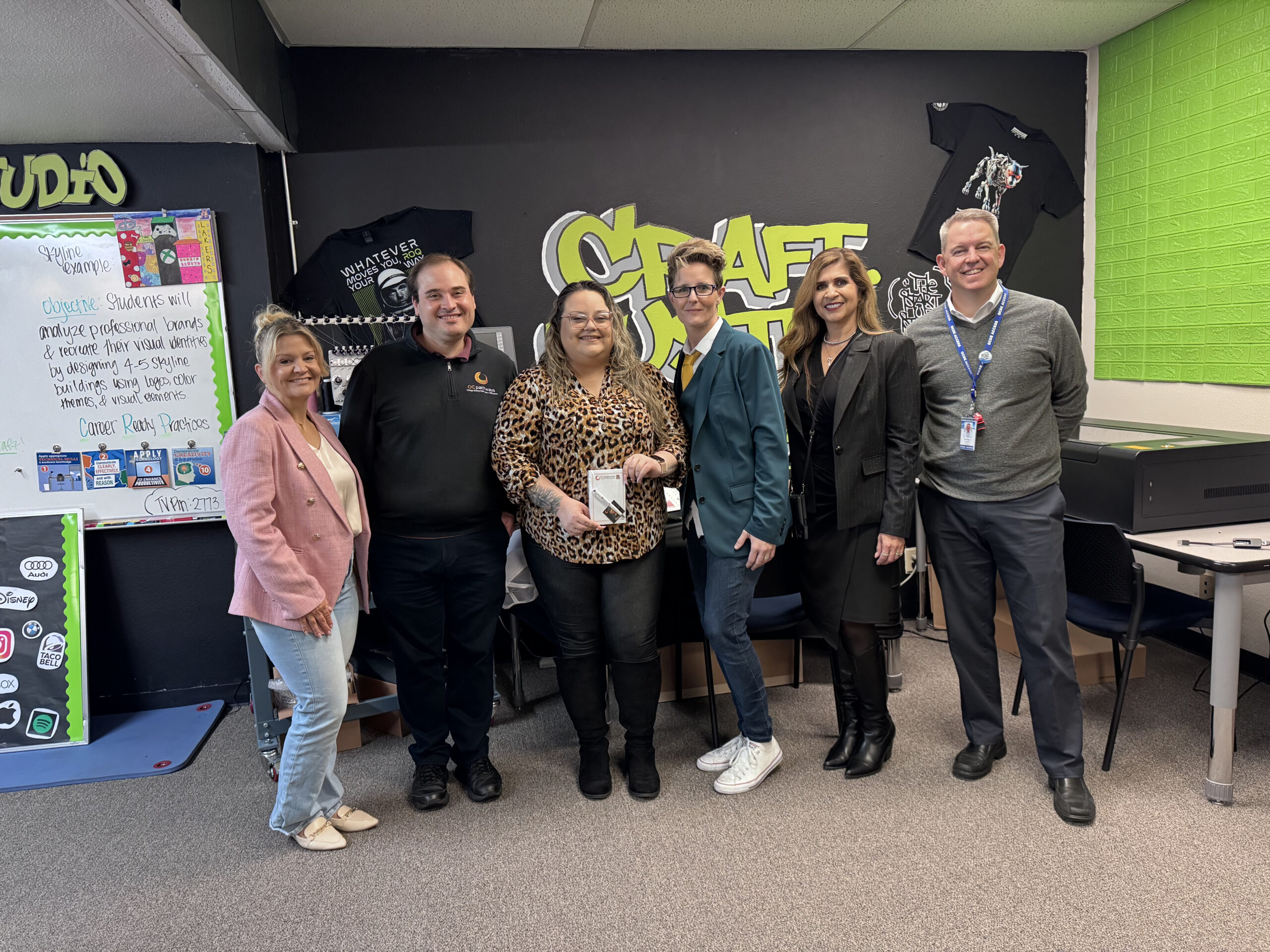 From left, Colleen Mangali, Steven Kahn, Monica Aguiar, Lauren Hartshorne, Dr. Jacqueline Cardenas and Erik Bagger gather during a CTE Month classroom recognition at an OCDE ACCESS site.