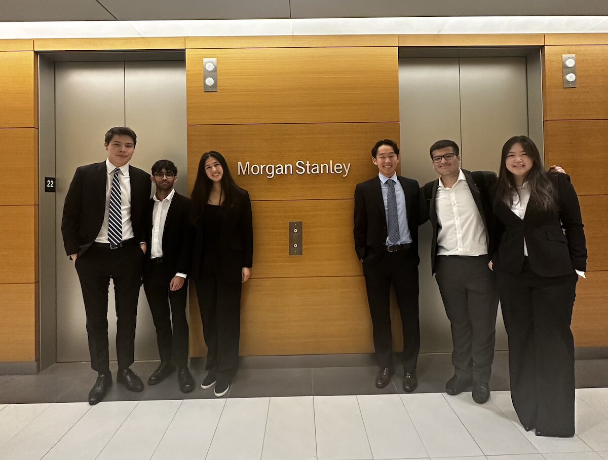 six people in suits standing in front of elevators