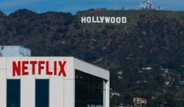 A Netflix sign is displayed atop a building in Los Angeles, on Dec. 18, 2025, with the Hollywood sign in the distance. (AP Photo/Jae C. Hong, File)