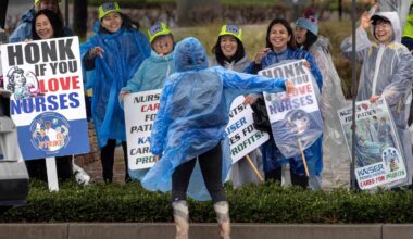 Striking Kaiser Permanente nurses and health care workers in the rain outside the Anaheim hospital, on February 16, 2026.